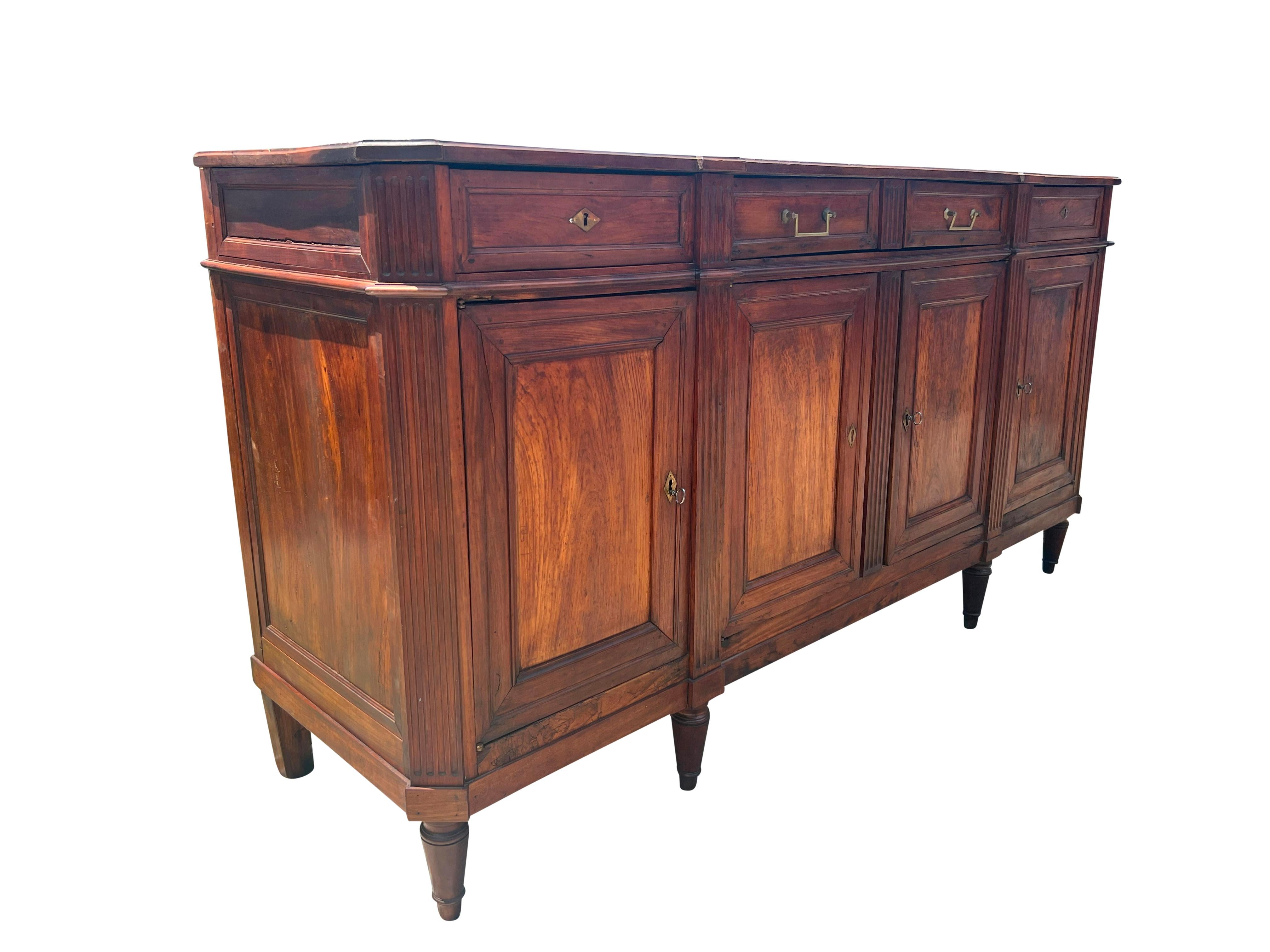 Rectangular top over a long center drawer flanked by a pair of drawers over a pair of cabinet doors flanked by doors. Fluted canted corners. Raised on circular tapered legs. From a Hamilton Mass estate. Key.