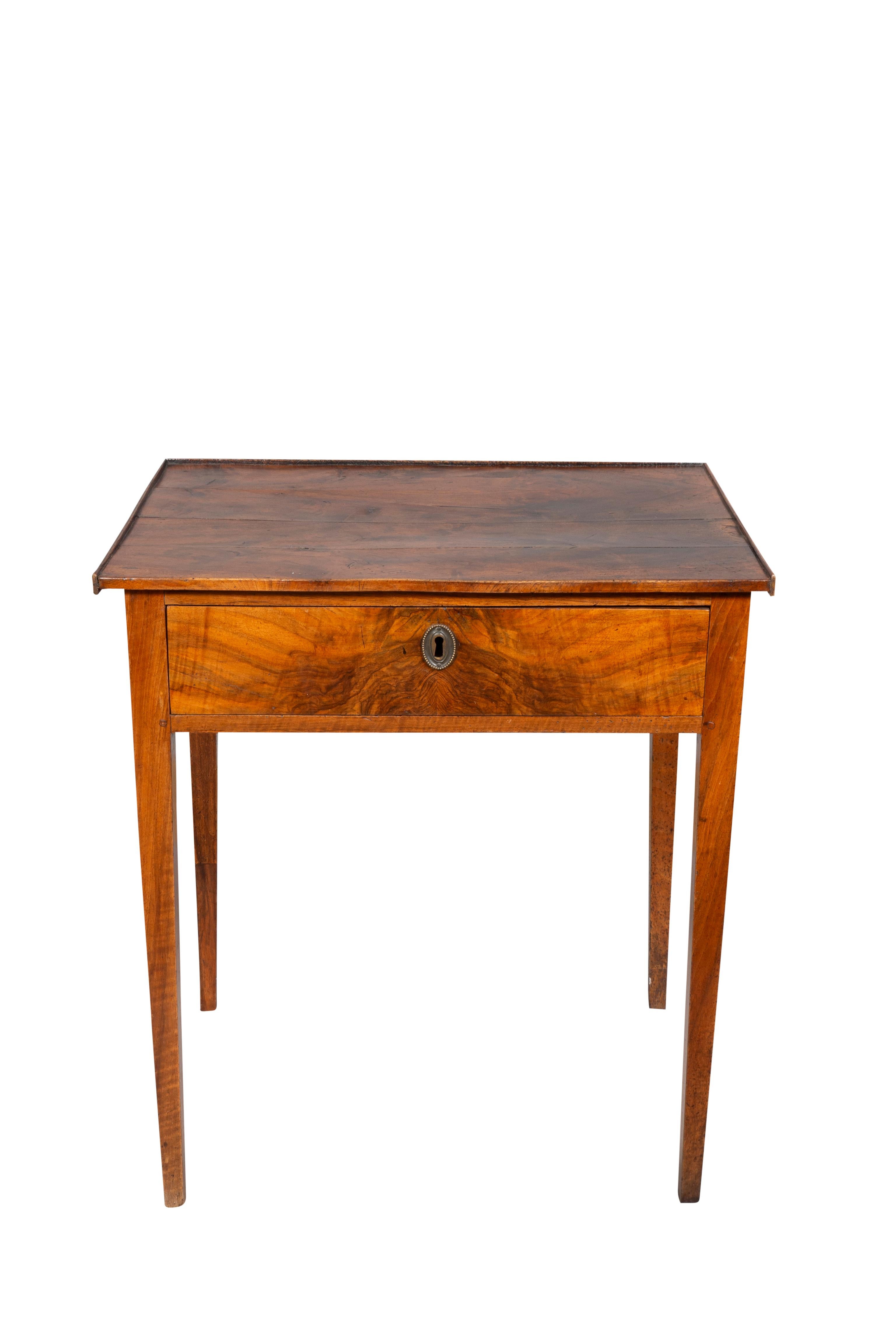 With a rectangular top over a drawer raised on square tapered legs.
