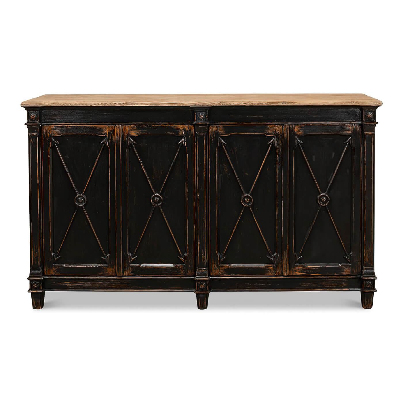 A French Directoire style antiqued buffet with an ebonized finish to the four-door cabinet and with a natural pine top. Each door has a cross arrow design. This piece is crafted in pine and has an antiqued rustic finish. The interior has two