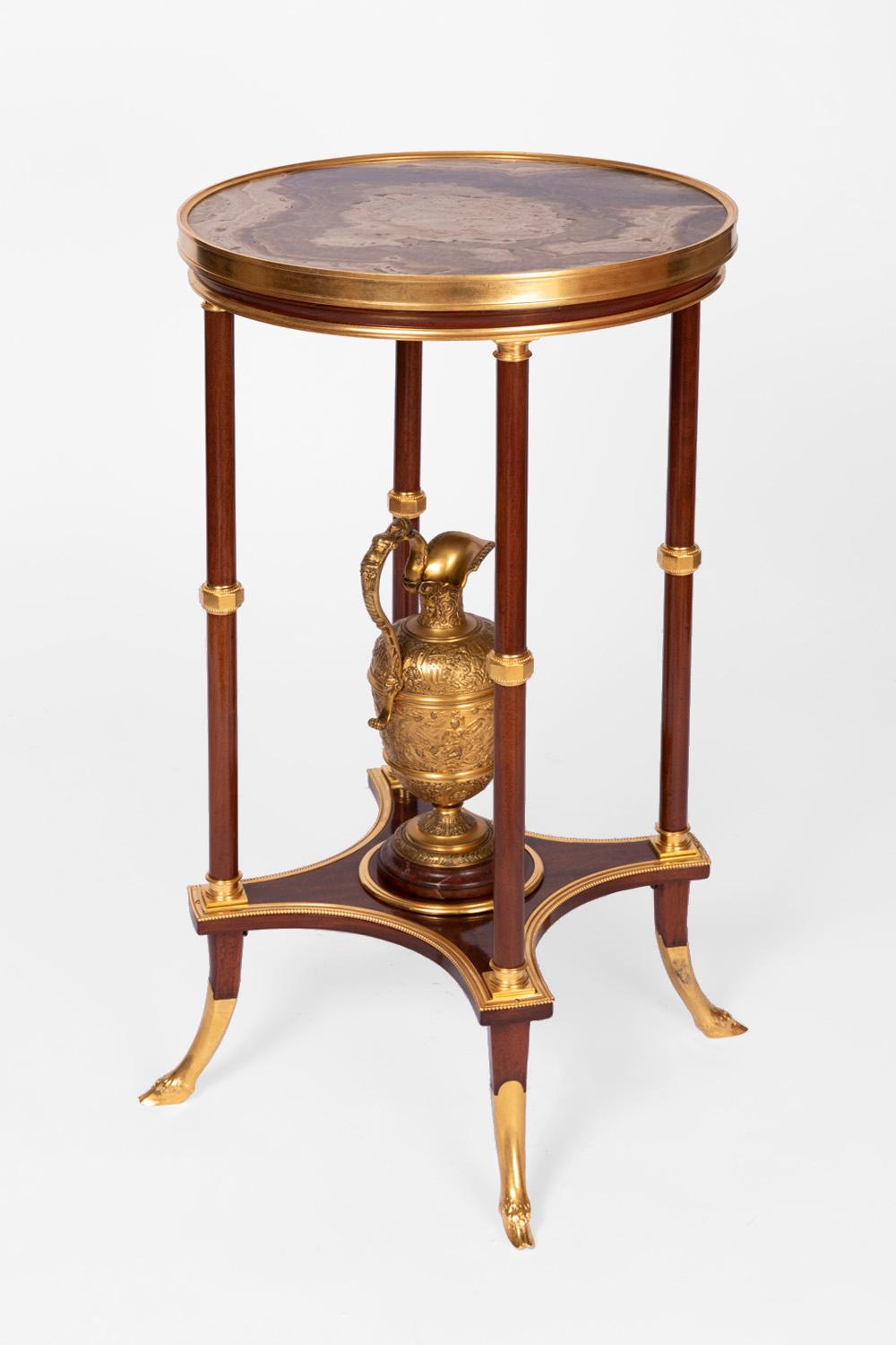French Directoire style athenienne pedestal table in mahogany, standing on four truncated legs finishing in saber shape. Greek cross shaped red cherry marble stretcher with curved angles, receiving a chiselled and gilt bronze ewer on a moulded
