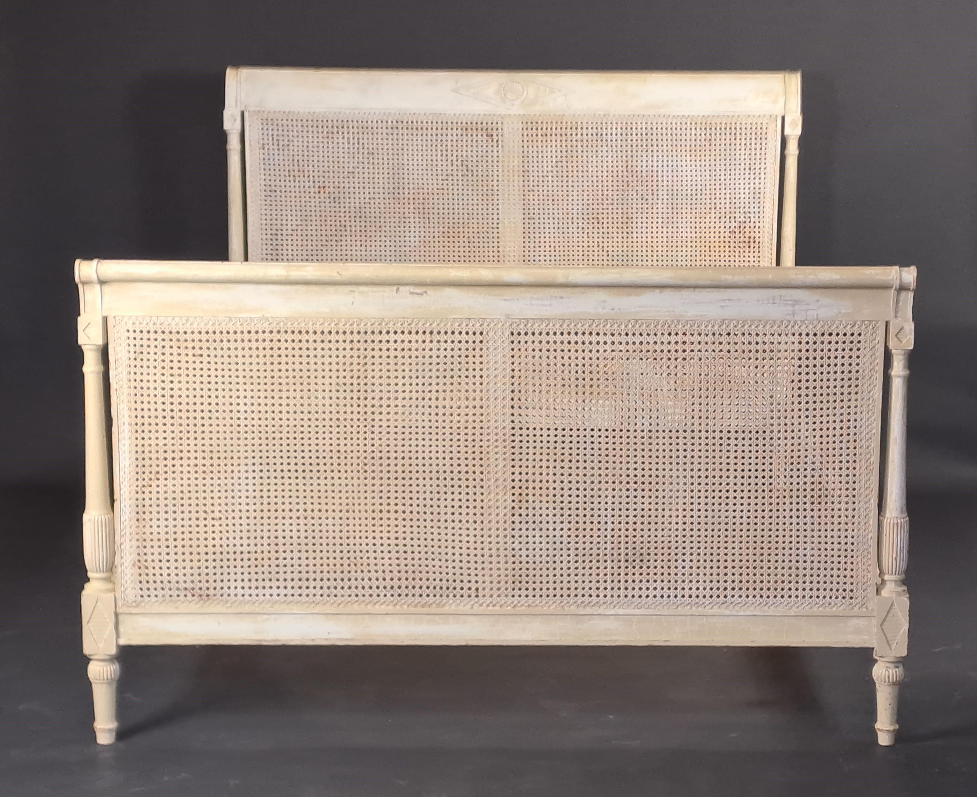 Bett im Directoire-Stil aus cremefarben lackiertem Holz auf weißem Grund und mit Kantholzverkleidung.
Qualitätsarbeit vom Ende des 19. Jahrhunderts.

Massive Buche.

Sehr guter Zustand, Gebrauchsspuren am Lack (originale Patina), keine