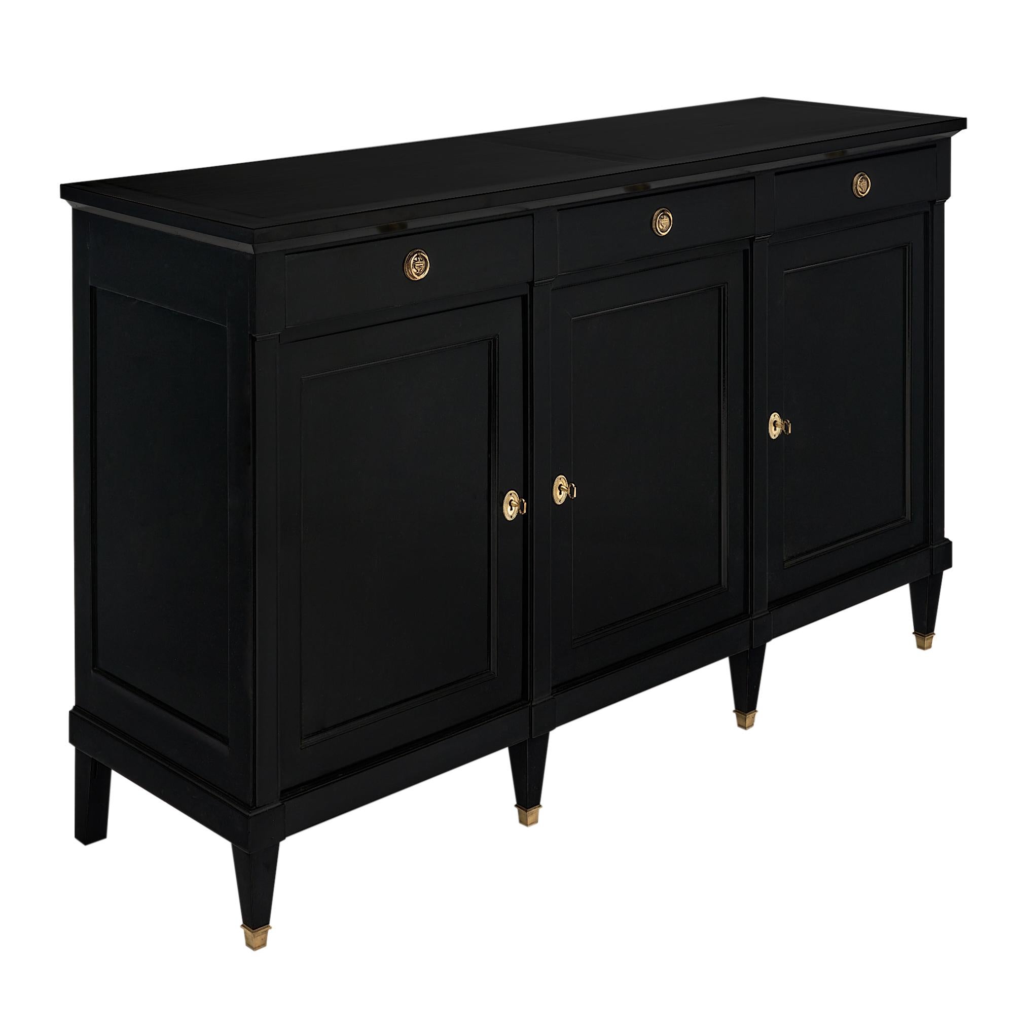 Buffet, enfilade, from France and made of mahogany that has been ebonized and finished in a lustrous museum-quality French polish. There are three doors that open to adjustable shelving. Three dovetailed drawers have brass hardware. The tapered