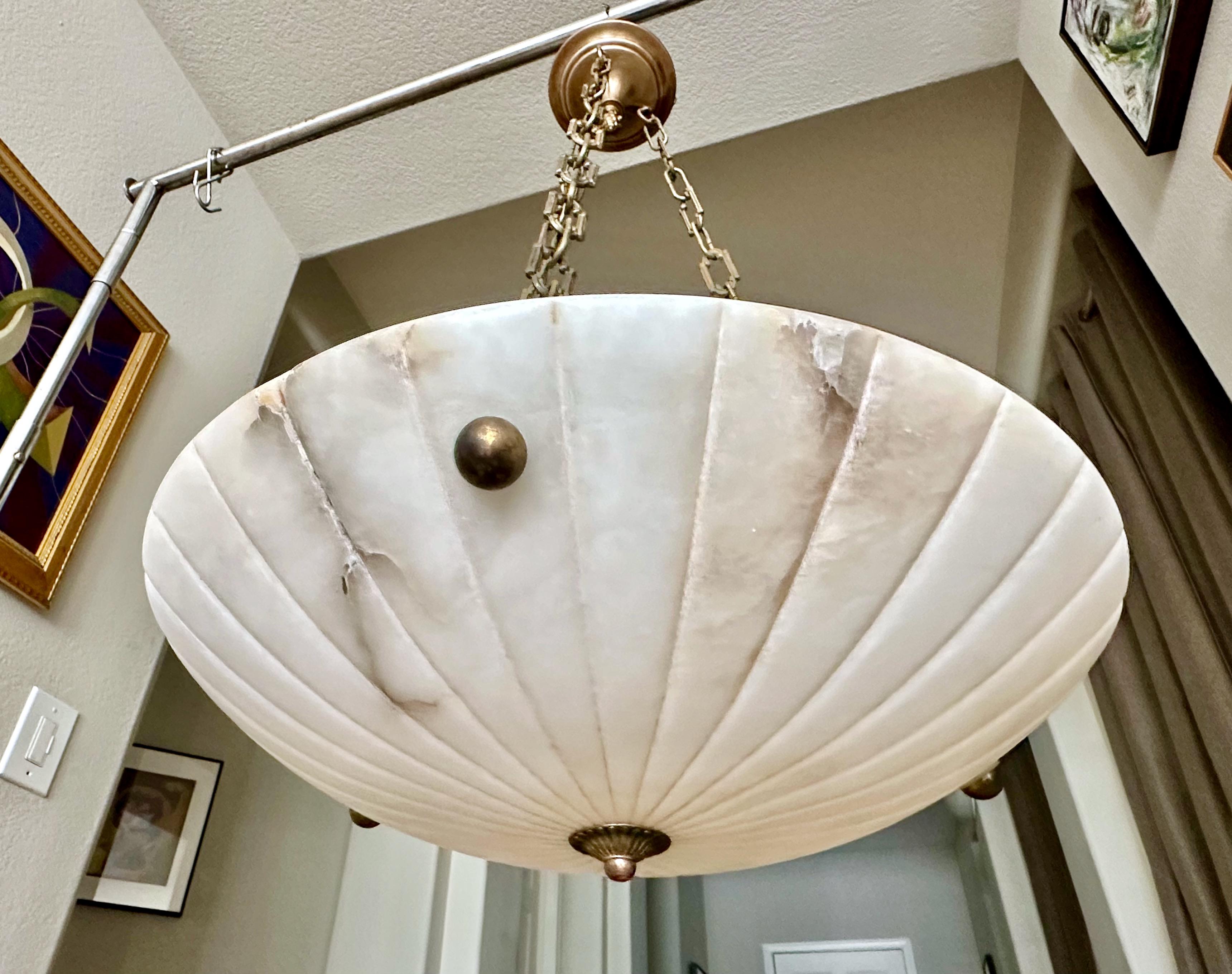 Lampada a sospensione in alabastro francese con finiture in ottone invecchiato (anticato) in stile Directoire. L'illuminazione interna utilizza 3 lampadine normali da 60 watt con base A (si consigliano i led). Cablata di recente. 
