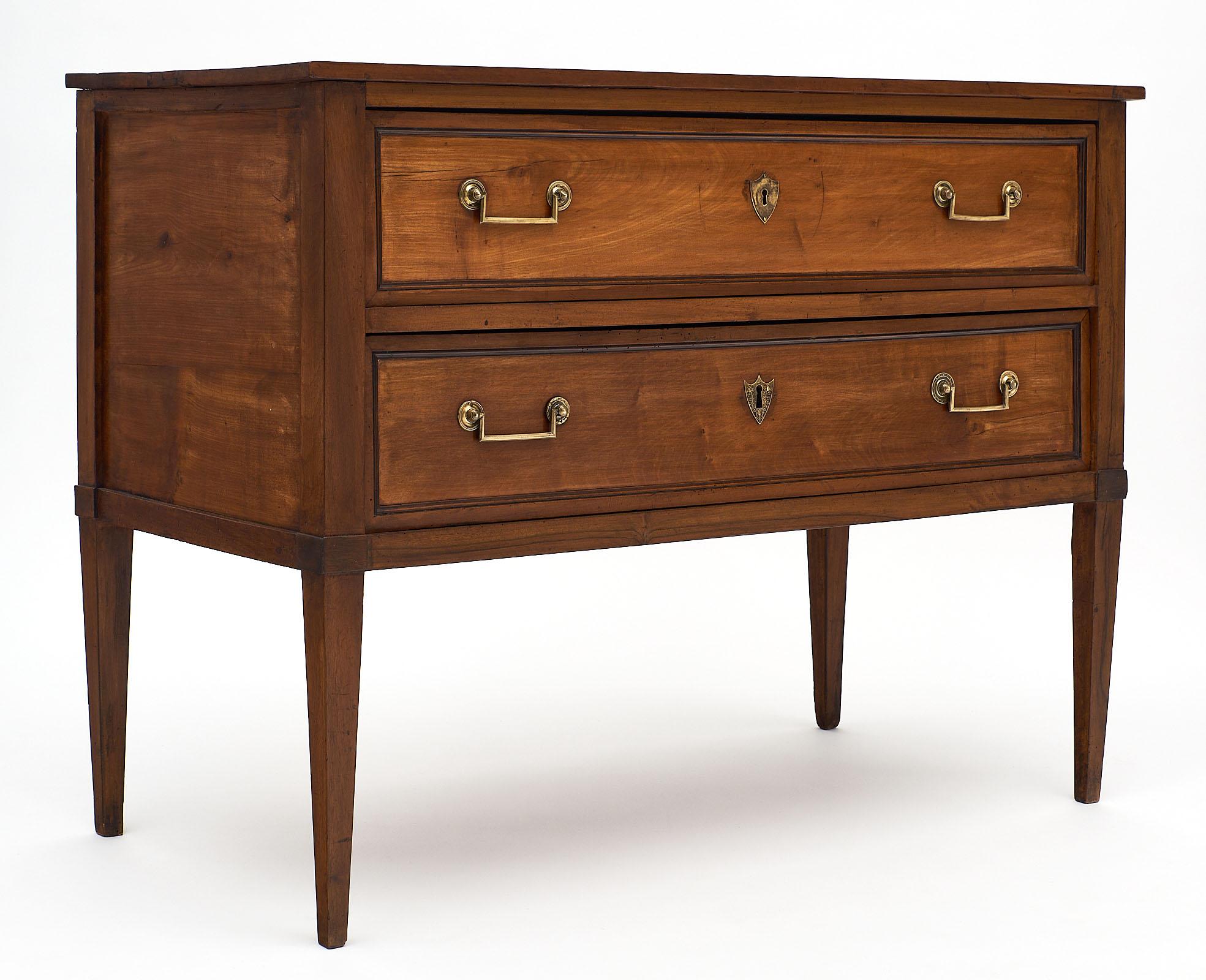 Fine French antique Directoire style chest of drawers made of solid walnut and featuring square brass pulls on two dovetailed drawers. We loved the solid walnut top, elegant proportions, and tapered legs.