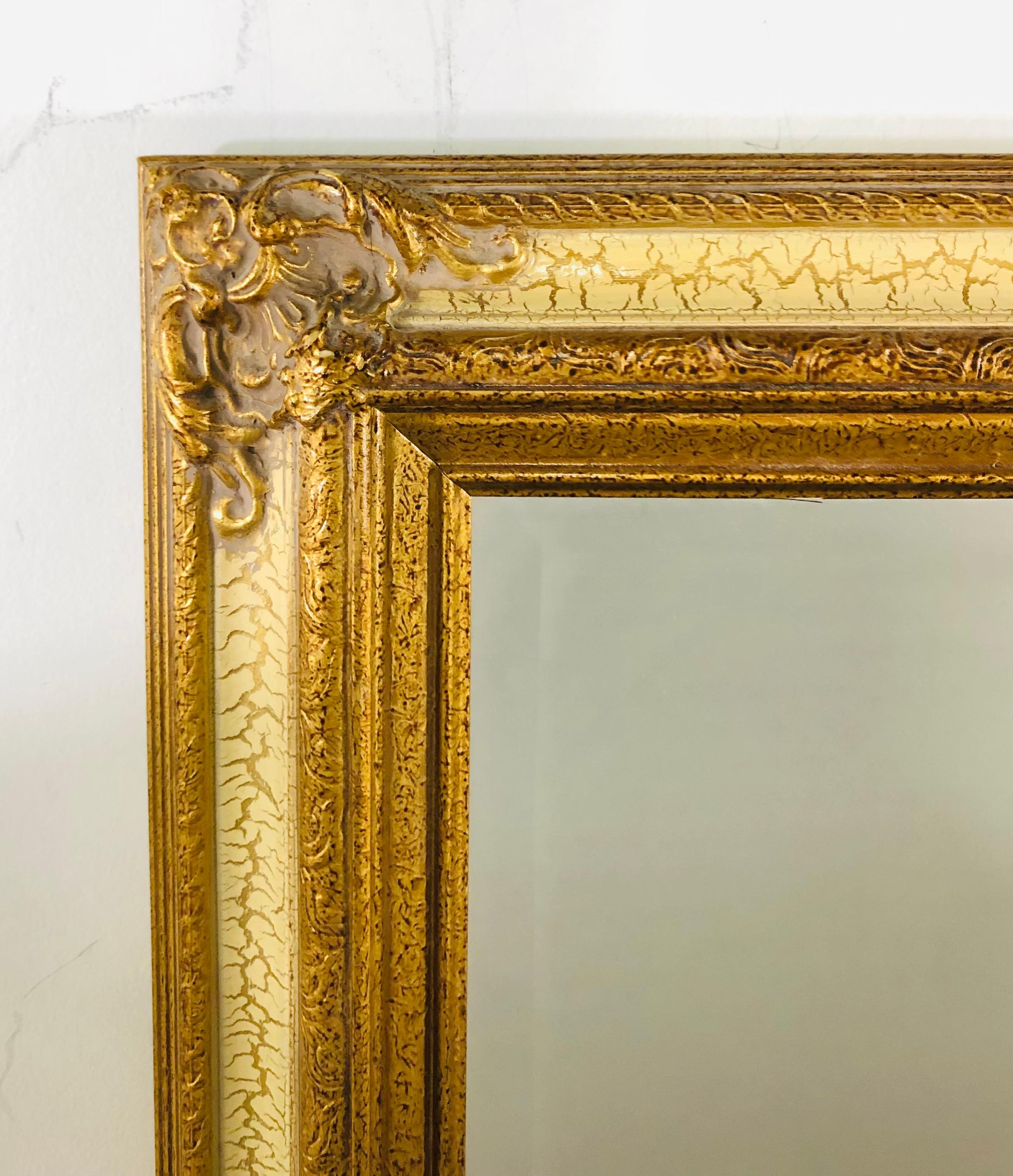 Un beau miroir mural ou de table de style Directoire français. Le cadre est finement sculpté et fait de bois doré avec un design patiné blanc cassé. Le verre du miroir est biseauté et le style général du miroir est intemporel et rehaussera le design