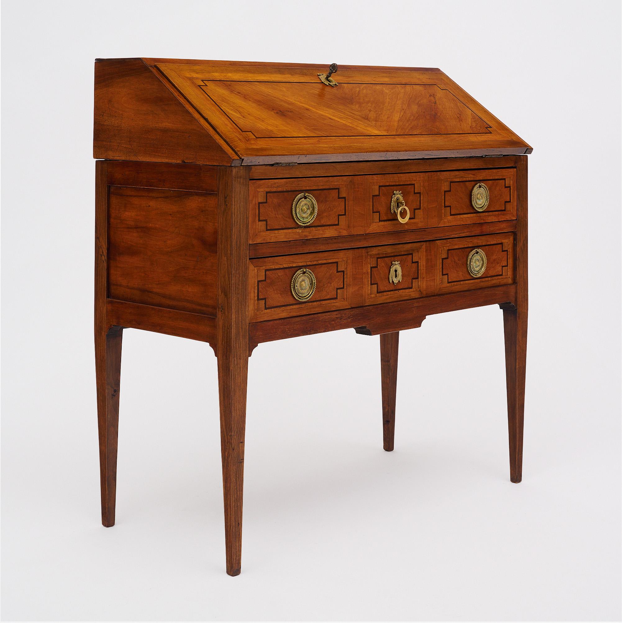 Secretary desk in the Directoire style from France. This piece is made of solid wood construction, primarily walnut. It has been finished with a lustrous French polish of museum quality. The drop top locks with a working key. It opens to a brown
