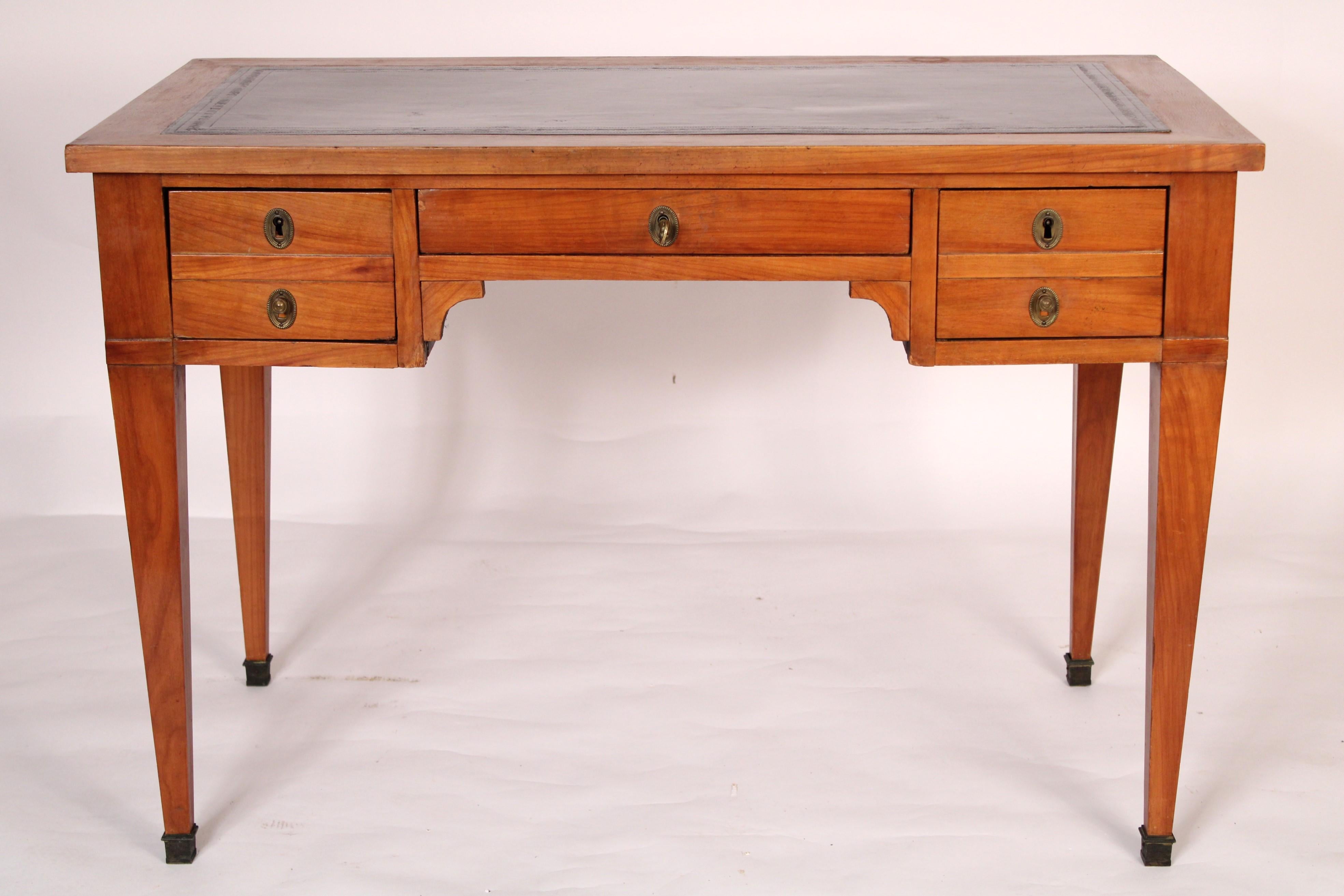 Directoire Style fruitwood leather top writing table / desk made from 19th century and later elements. With a rectangular leather top with fruitwood borders, central frieze drawer flanked by one double drawer on both right and left sides, sides with