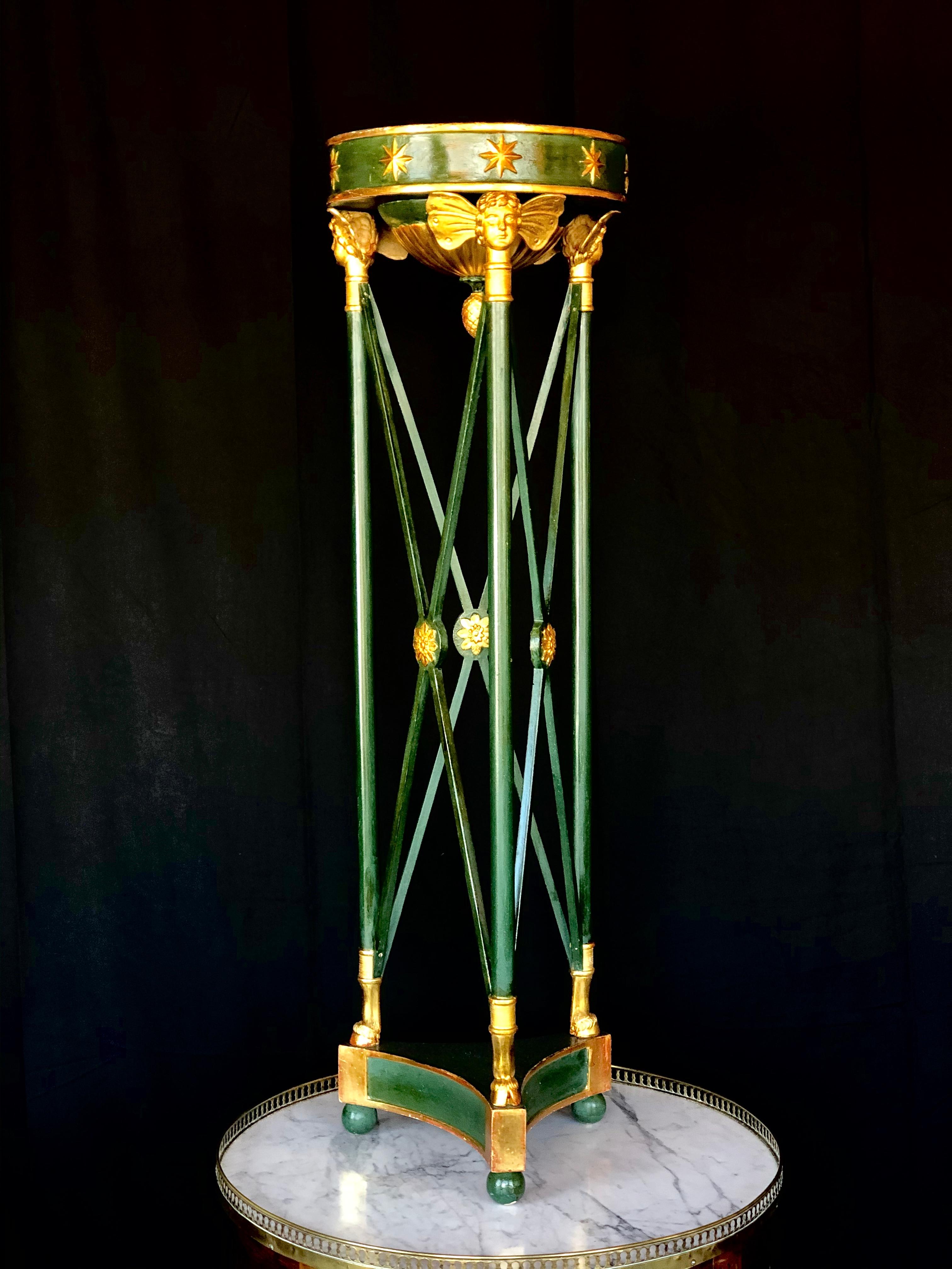 A handsome green painted neoclassical stand with gilt accents. Early 20th century.