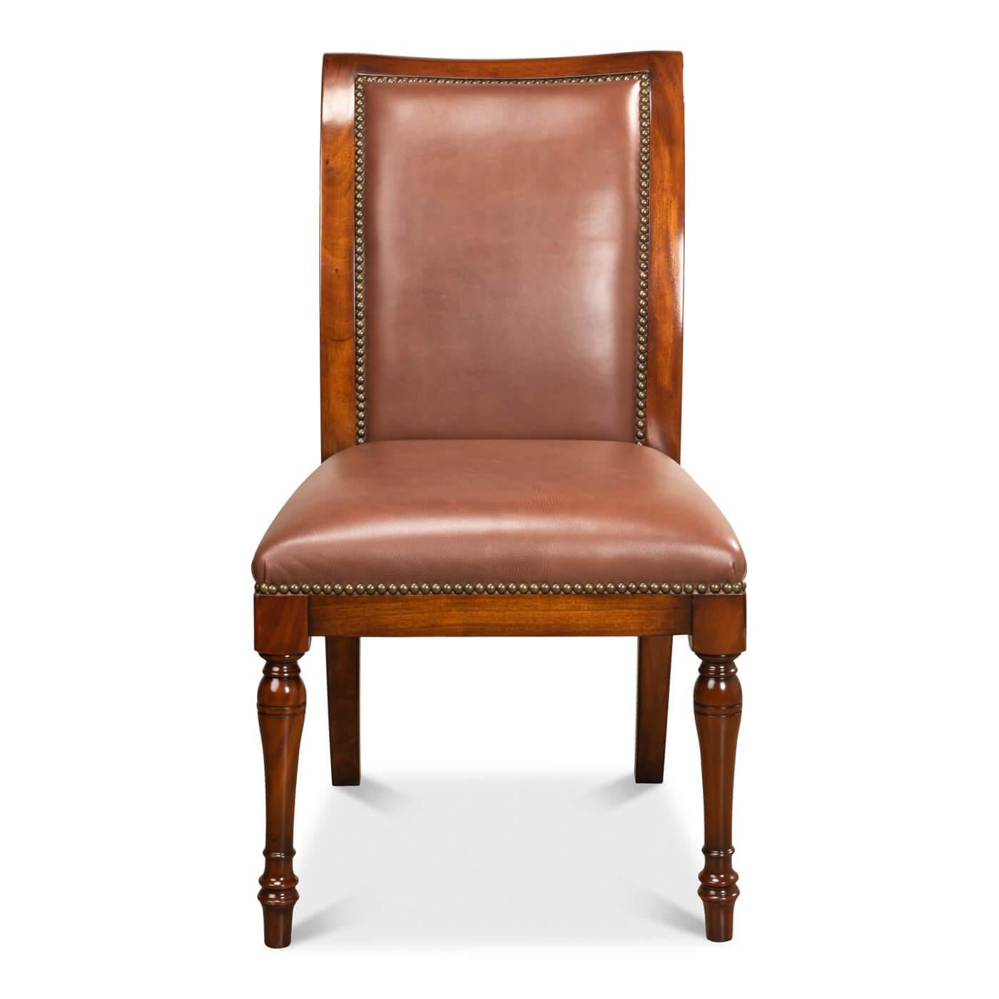 A French Directoire style leather dining chair upholstered with brown leather to the seat and back, in a warm walnut finish, supported on slender turned tapering legs, and finished with brass nailhead trim.

Dimensions: 21