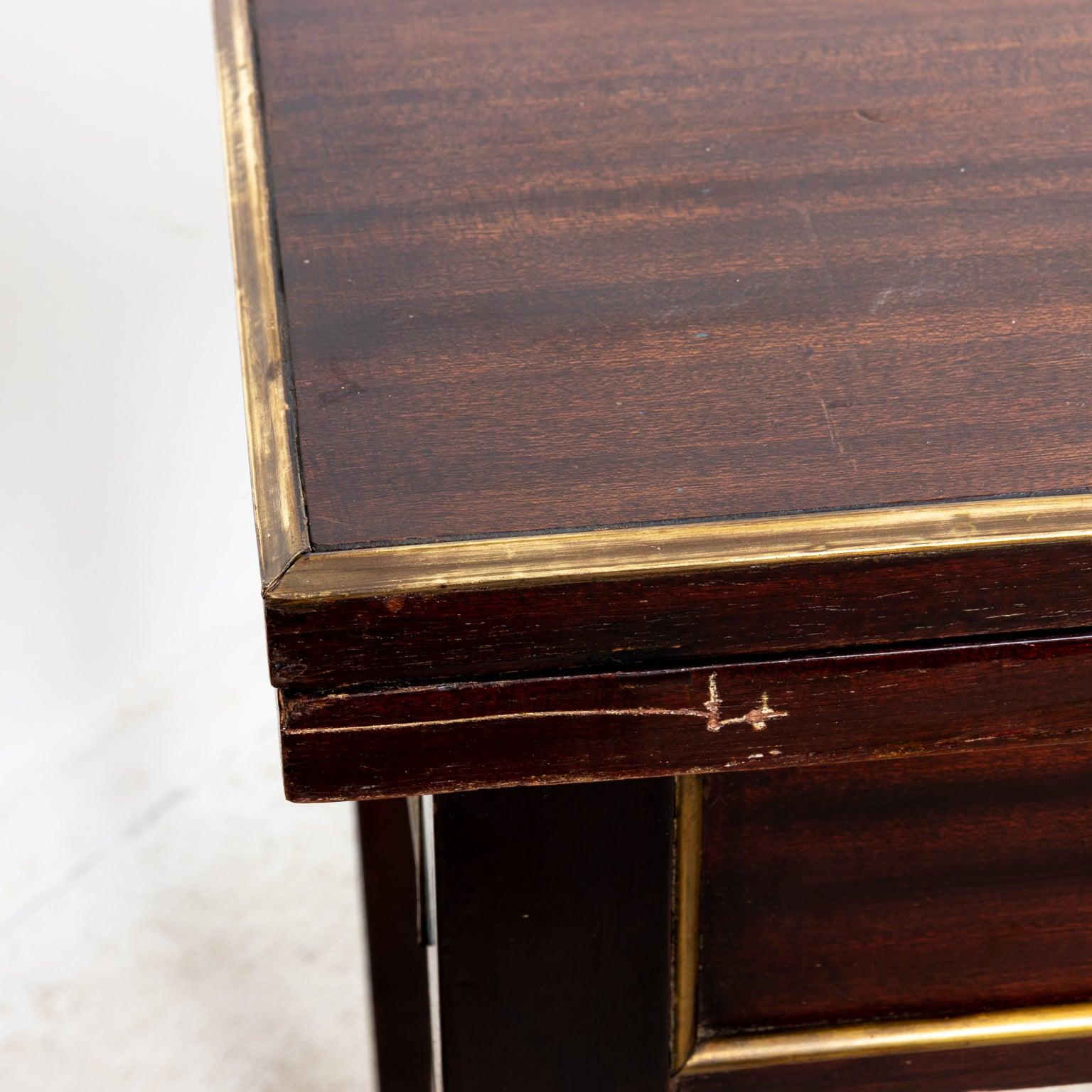 Mahogany table with brass quarter round branding on sides and brass carved banding inlay on top on four tapered legs capped with brass feet. Table opens to 64