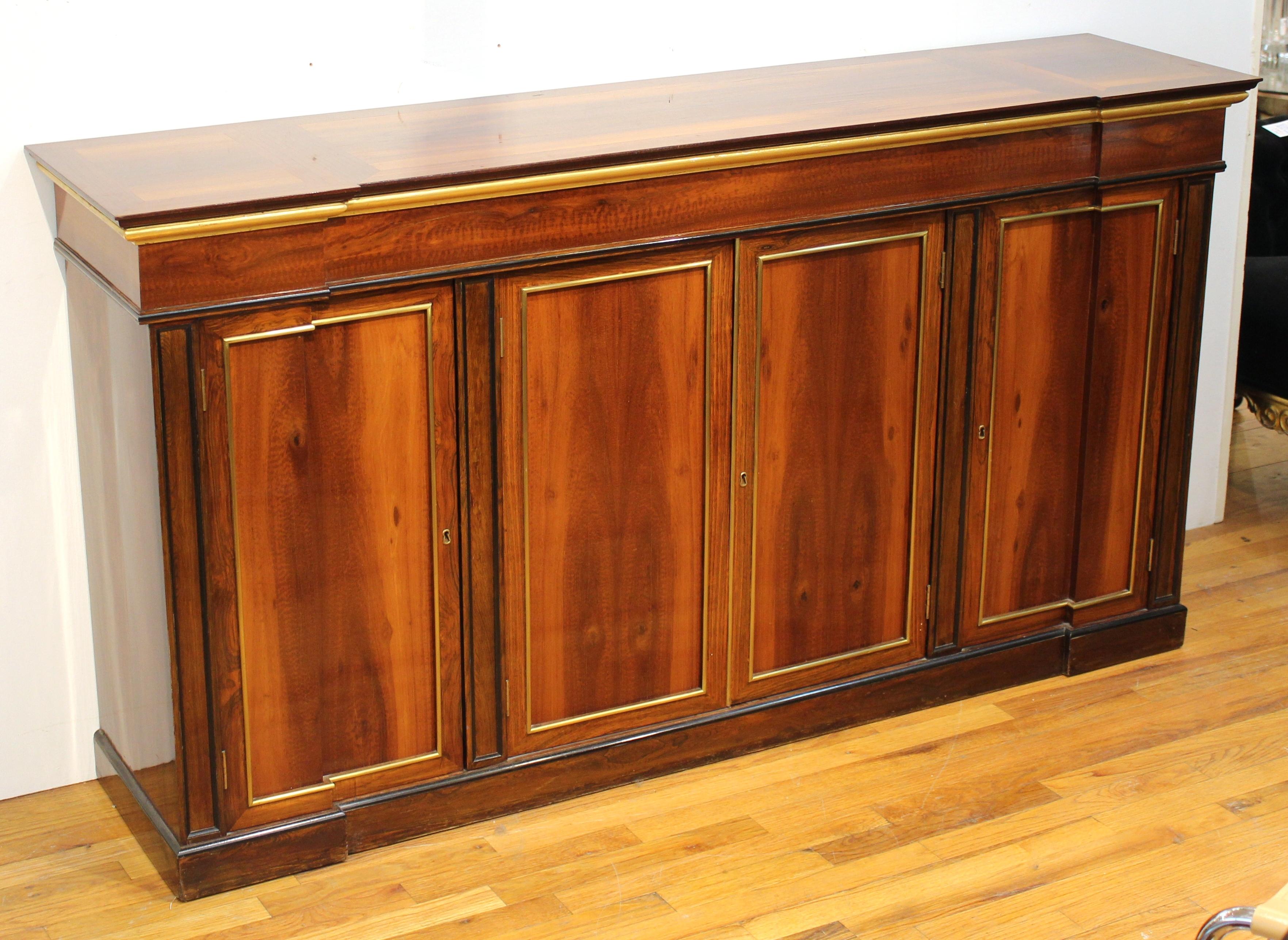 Directoire style mahogany sideboard or console, shaped top over double swing doors at center flanked by single doors, brass mounts. Measures: 36