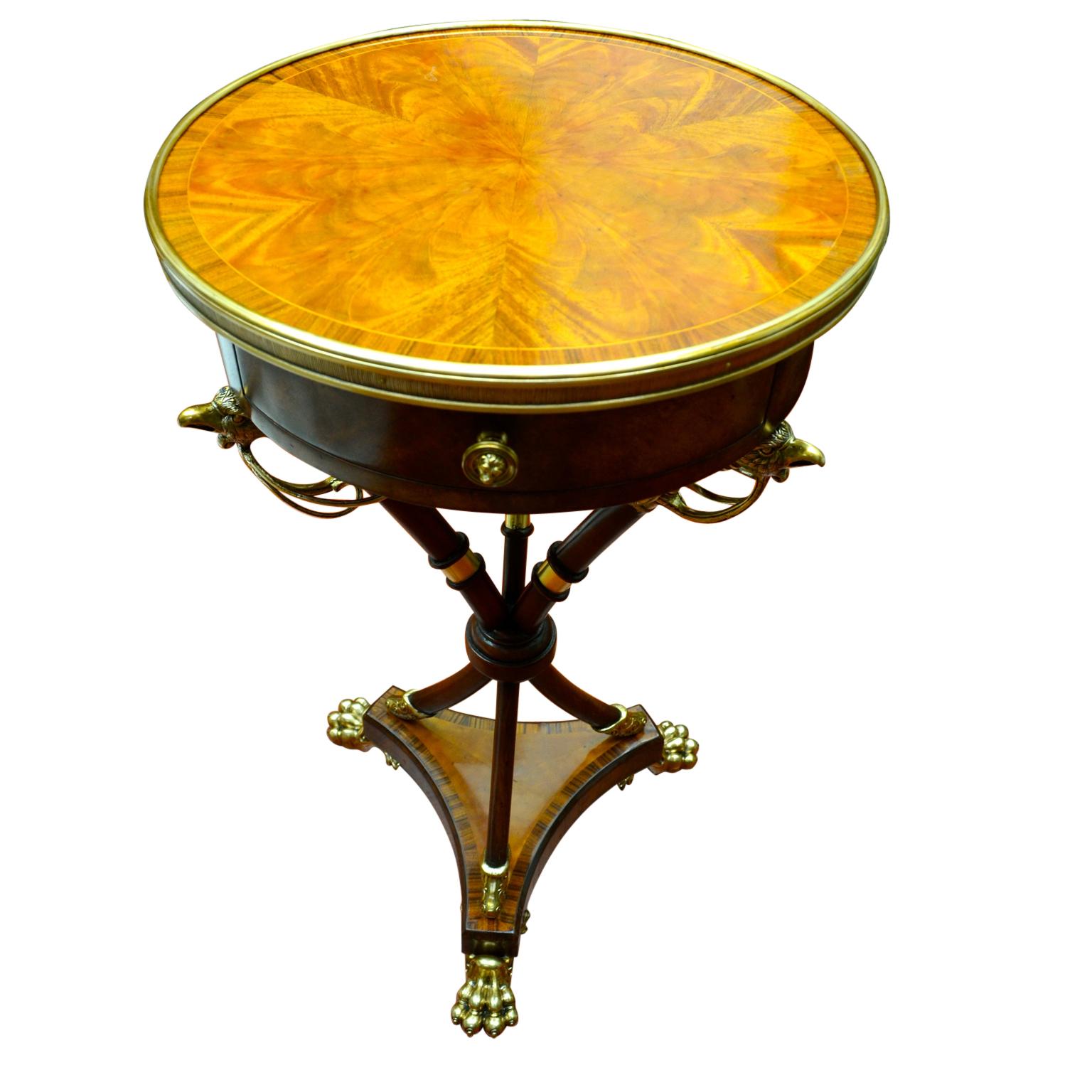 An unusual and highly decorative occasional table in the French Directoire/Regency style. The beautifully inlaid circular top with gilded metal banding has one drawer on the skirt; the inside bottom of the drawer has an affixed round silvered
