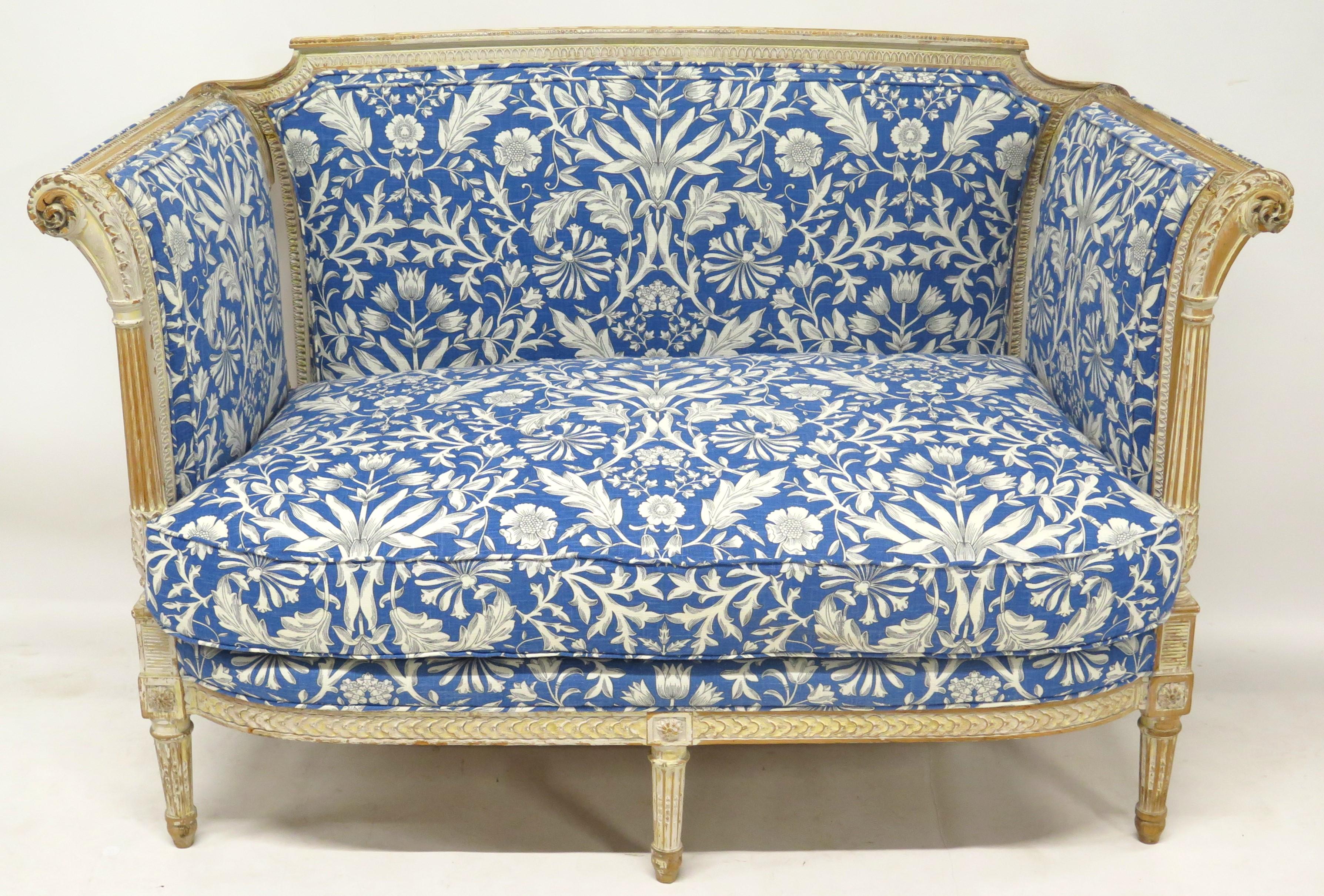 un beau canapé de style Directoire avec cadre sculpté et peint en blanc, confortable coussin d'assise simple, dossier et côtés rembourrés, beau tissu à motifs floraux bleu et blanc, le cadre en bois du canapé est étonnant, France, fin du 19ème siècle