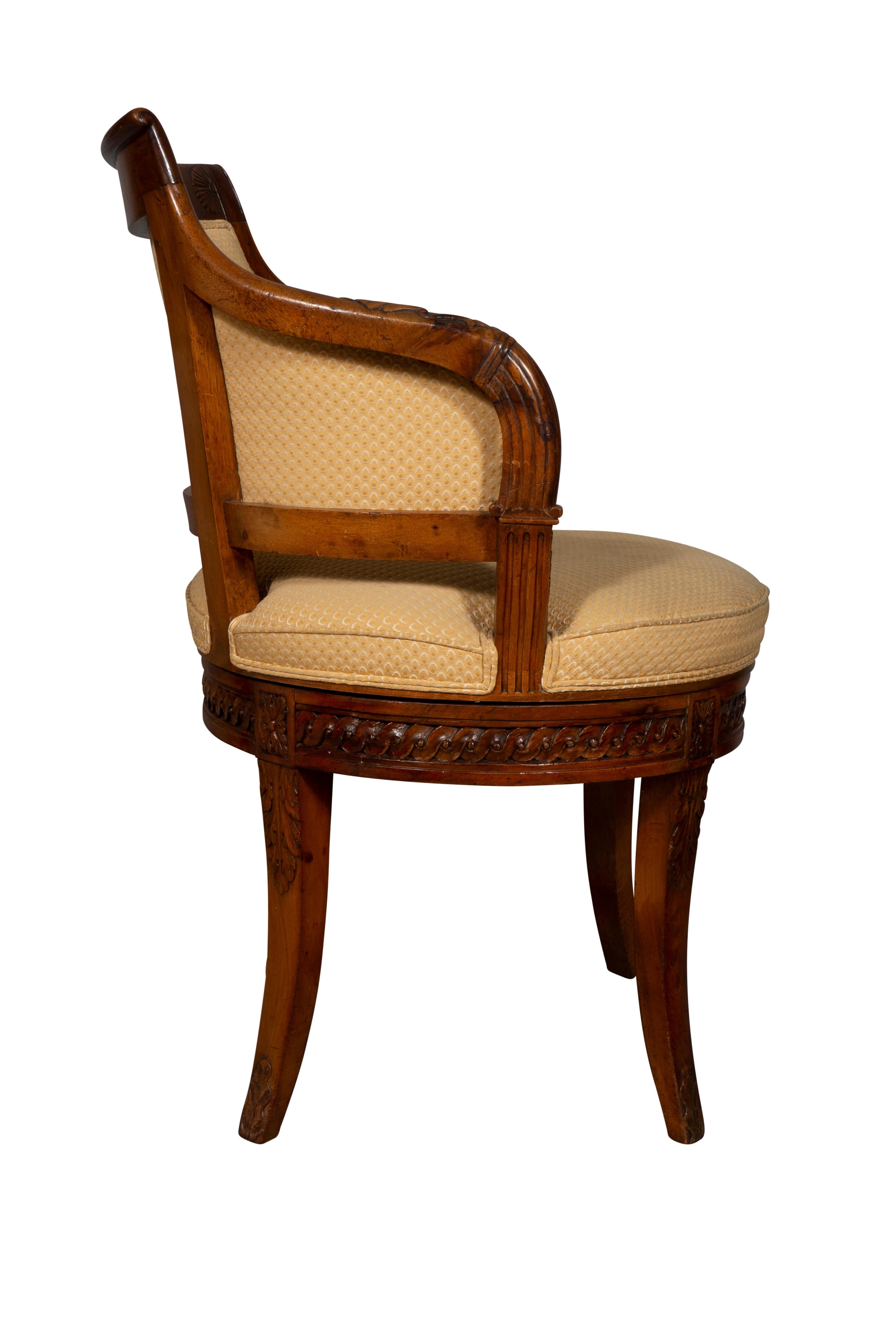 The curved back with crest rail carved with a central urn, the carved down swept arms joining the seat. The seat swivels. The seat rail with guilloche carving, raised on carved tapered saber legs. Needs reupholstery. Frame solid.