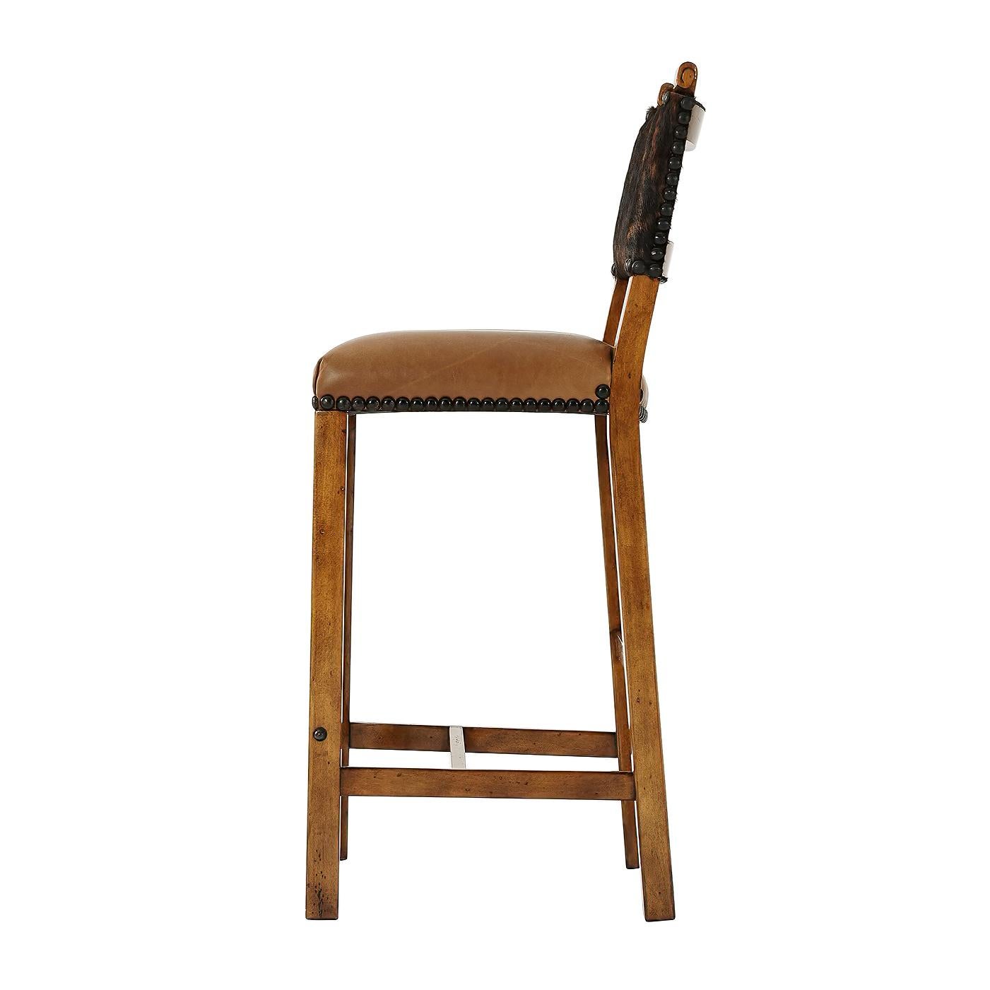 A Director's bar chair, the padded back above an upholstered seat, on square supports and stretchers with a brass footrest.
Dimensions: 20