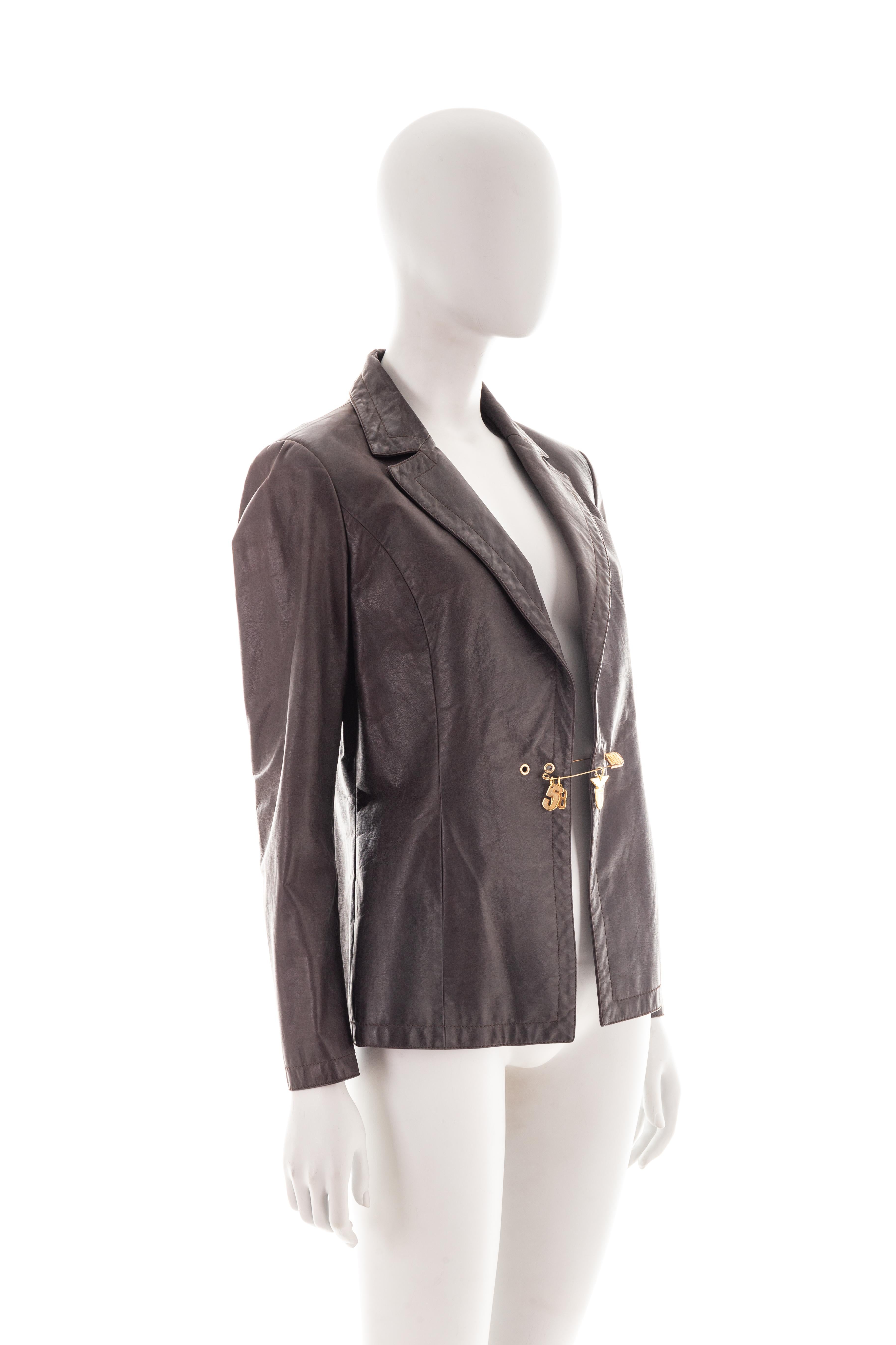 - Mid 2000s
- Sold by Gold Palms Vintage
- Dark brown leather jacket
- Gold safety pin fastening with charms 
- Size: IT 44
