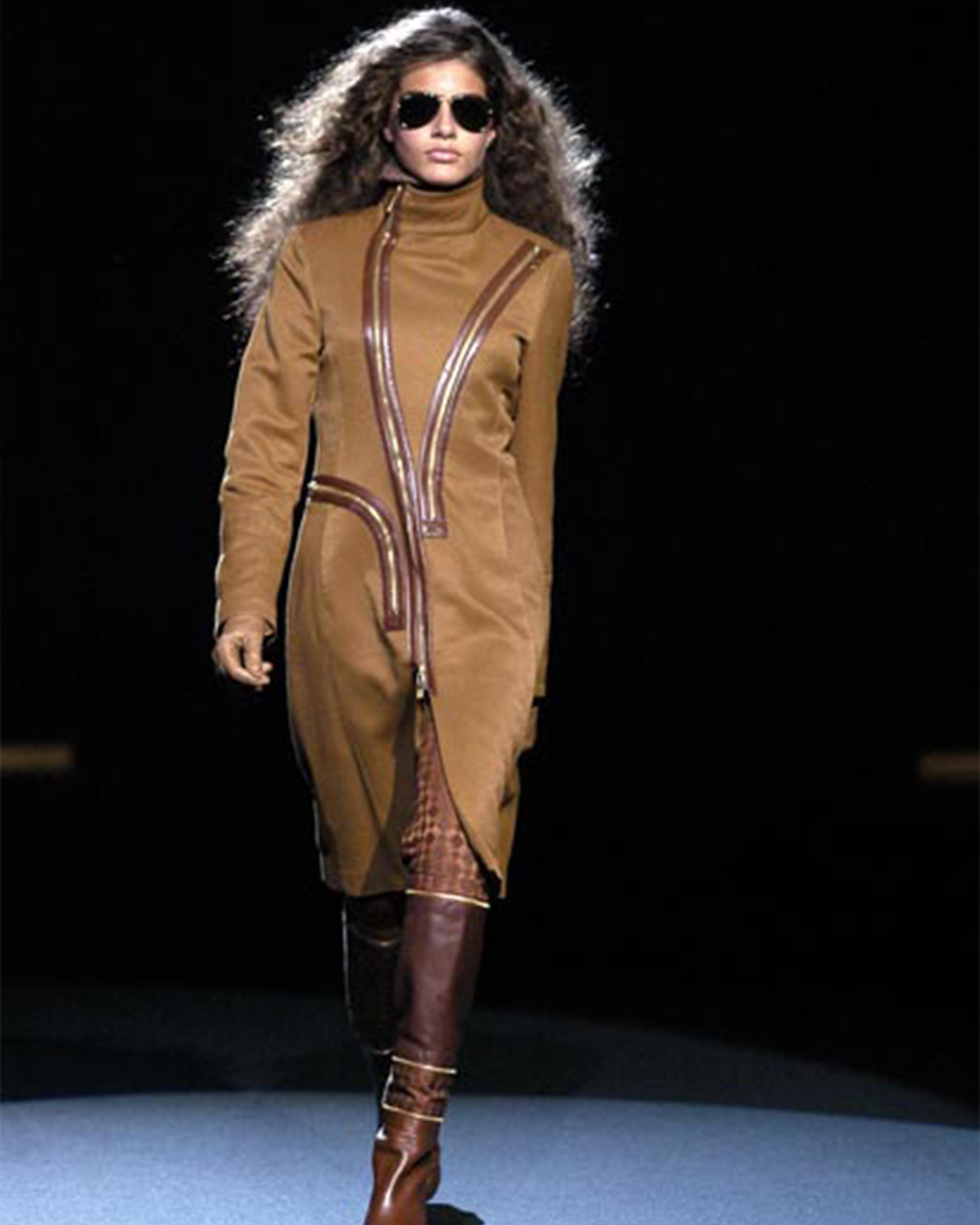 - Designed by Dirk Bikkembergs
- Fall Winter 2004
- Zipped Brown Cotton Coat
- High neckline
- Multiple zips with red leather details
- Two pockets on the front
- Metal gold hardware
- Very good condition: some little holes on the lining but not