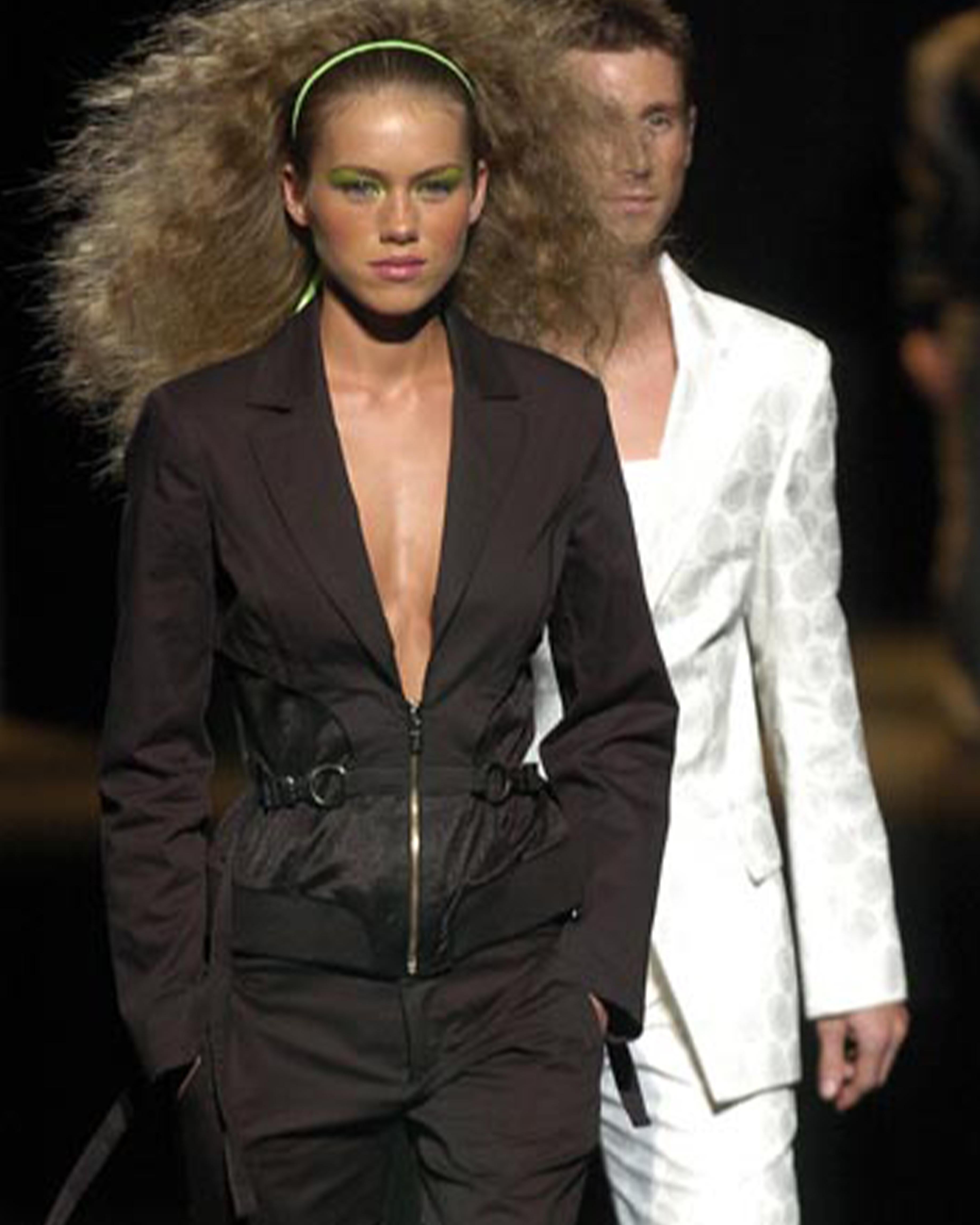 - Entworfen von Dirk Bikkemebergs
- Frühjahr-Sommer-Kollektion 2005
- Laufstegstück
- Schwarzer Utility-Bondage-Blazer
- Frontalreißverschluss
- Bondage-Anwendungen an der Taille
- Silberne Metallbeschläge
- Crop-Passform
- Sehr guter Zustand
-