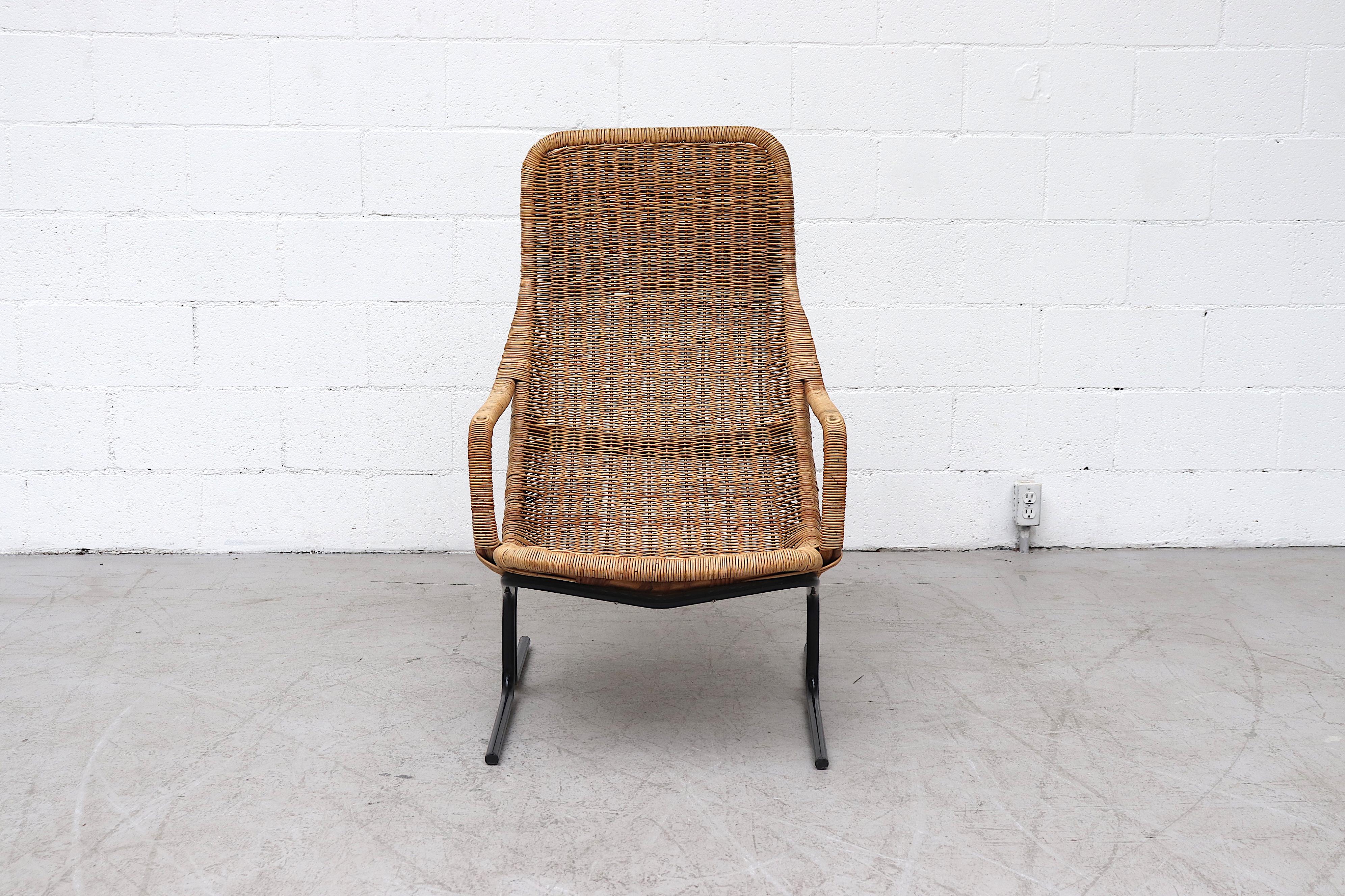 Beautiful Dirk Van Sliedregt high back woven rattan lounge chair with tubular black enameled metal frame in original condition with visible signs of wear and minimal rattan loss.