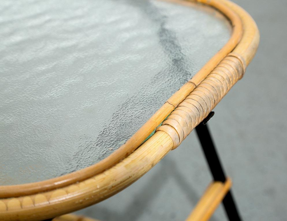 Dirk van Sliedregt, ein niederländischer Möbeldesigner, der für seine innovativen und eleganten Entwürfe berühmt ist, hat einen bezaubernden niedrigen Tisch mit Glasplatte und Rattan entworfen, der seine Beherrschung von MATERIAL und Form