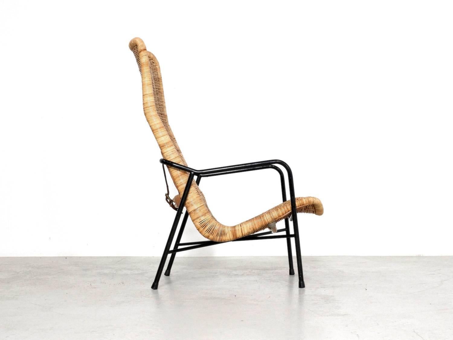 This rattan easy chair, model 514A, was designed by Dirk van Sliedregt in 1952 for Gebr. Jonkers in Noordwolde, Netherlands. It has a black metal frame, and a high back rattan bucket seat, which is connected to the frame by a leather belt at the
