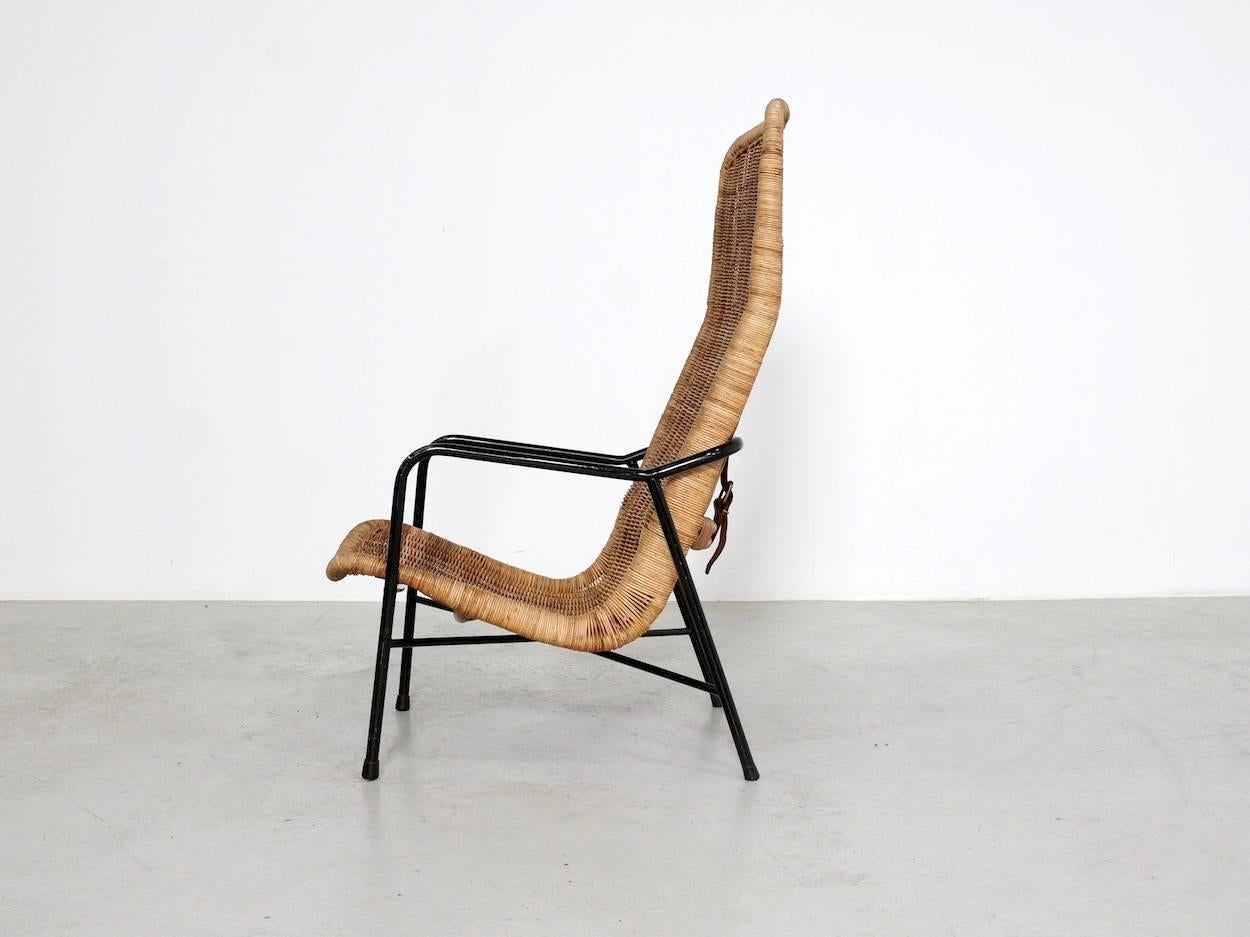 This rattan easy chair, model 514A, was designed by Dirk van Sliedregt in 1952 for Gebr. Jonkers in Noordwolde, Netherlands. It have a black metal frame, and a rattan high back rattan bucket seat, which is connected to the frame by a leather belt at