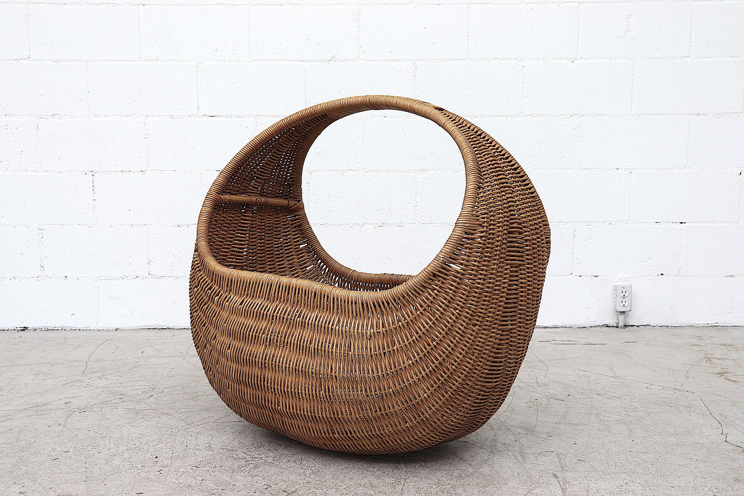 Beautiful, oversized, hand-woven rattan and bamboo baby basket. Comes with new, removable foam cushion and wood support inside. In good original condition with minimal breakage and moderate wear consistent with its age.