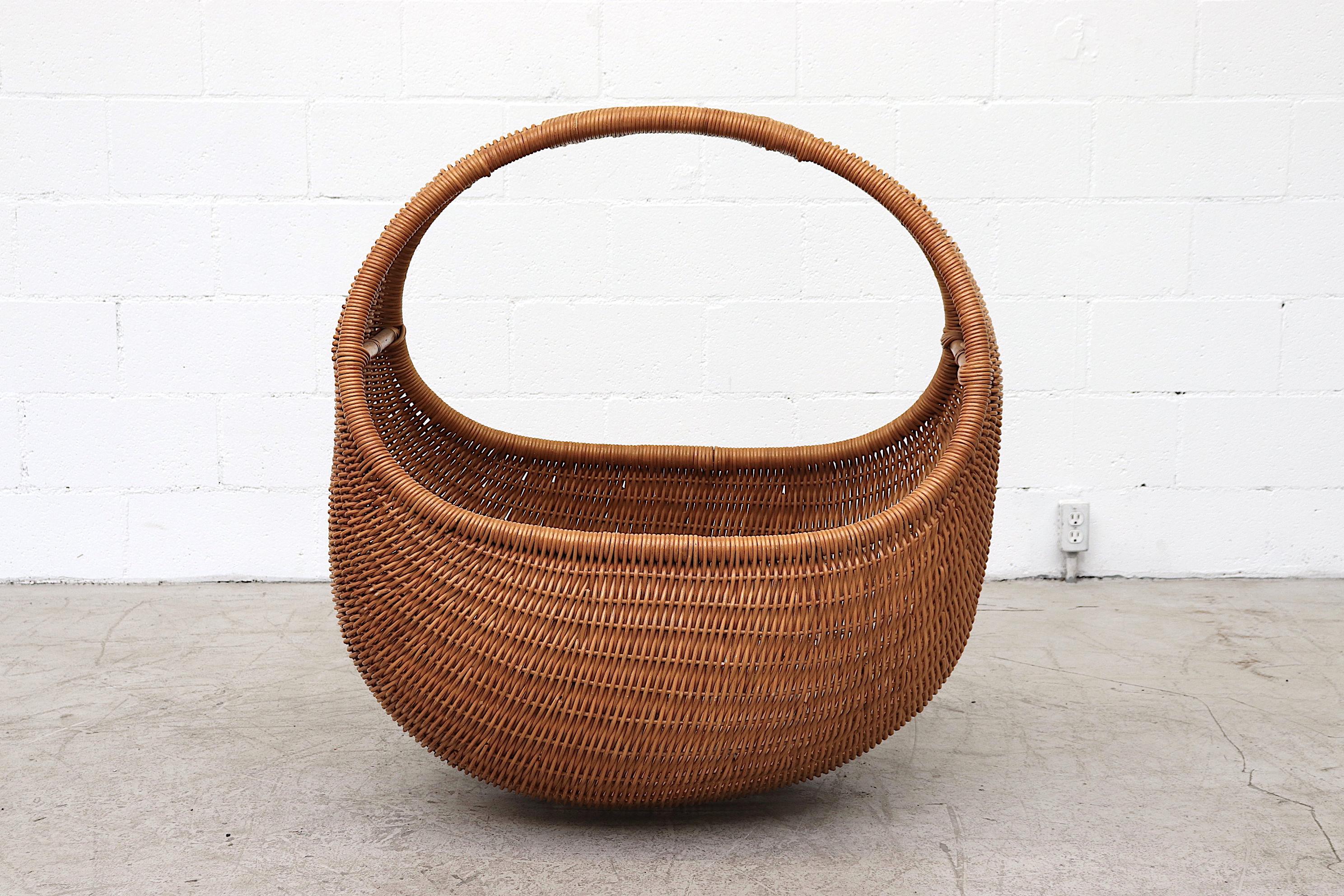 Beautiful Oversized Rattan Woven Bamboo Baby Basket with Foam Cushion and Wood Support Inside. In Good Original Condition with Minimal Breakage and Moderate Wear Consistent with its age. Two Available, Rattan Color Vary Slightly, please inquire.