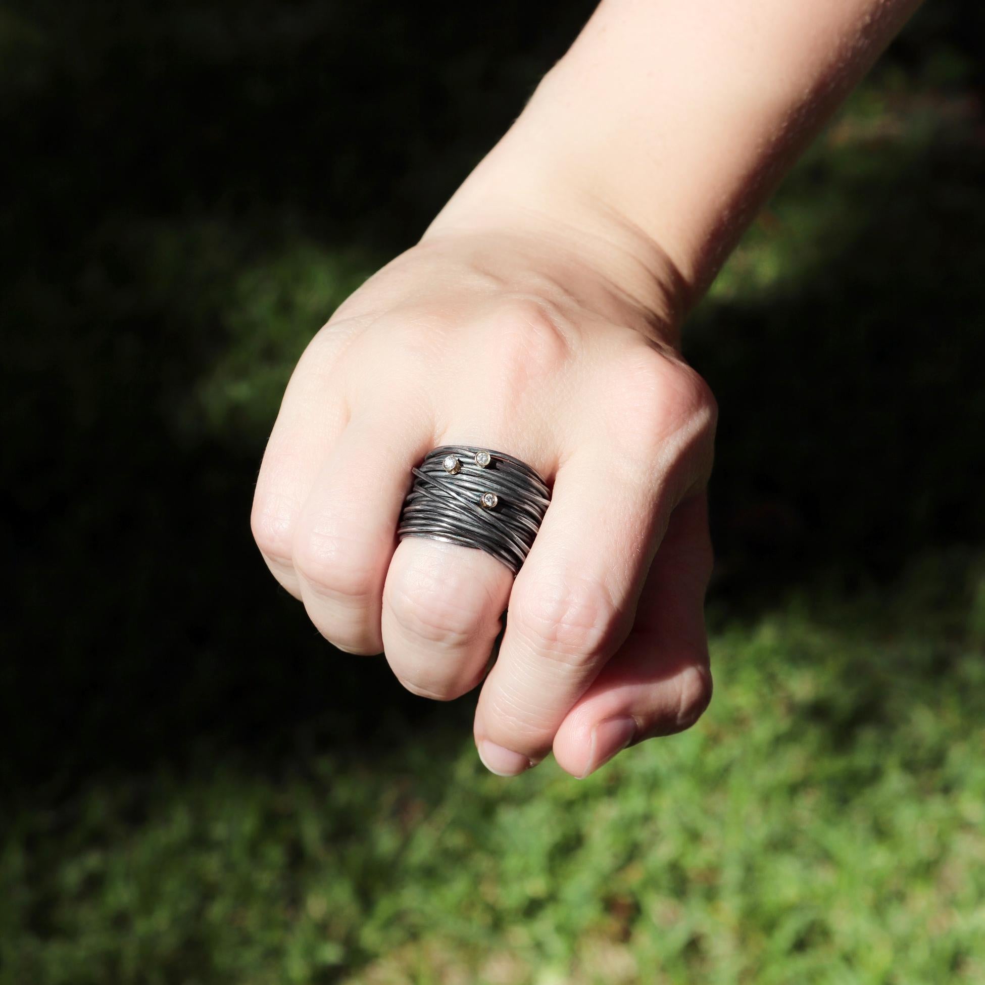 Spaghetti Wrap Band hand-fabricated in London by jewellery maker Disa Allsopp in oxidized sterling silver featuring three round brilliant-cut white diamonds totaling 0.03 carats bezel-set in 18k yellow gold. Size 7.5. Stamped and Hallmarked. 