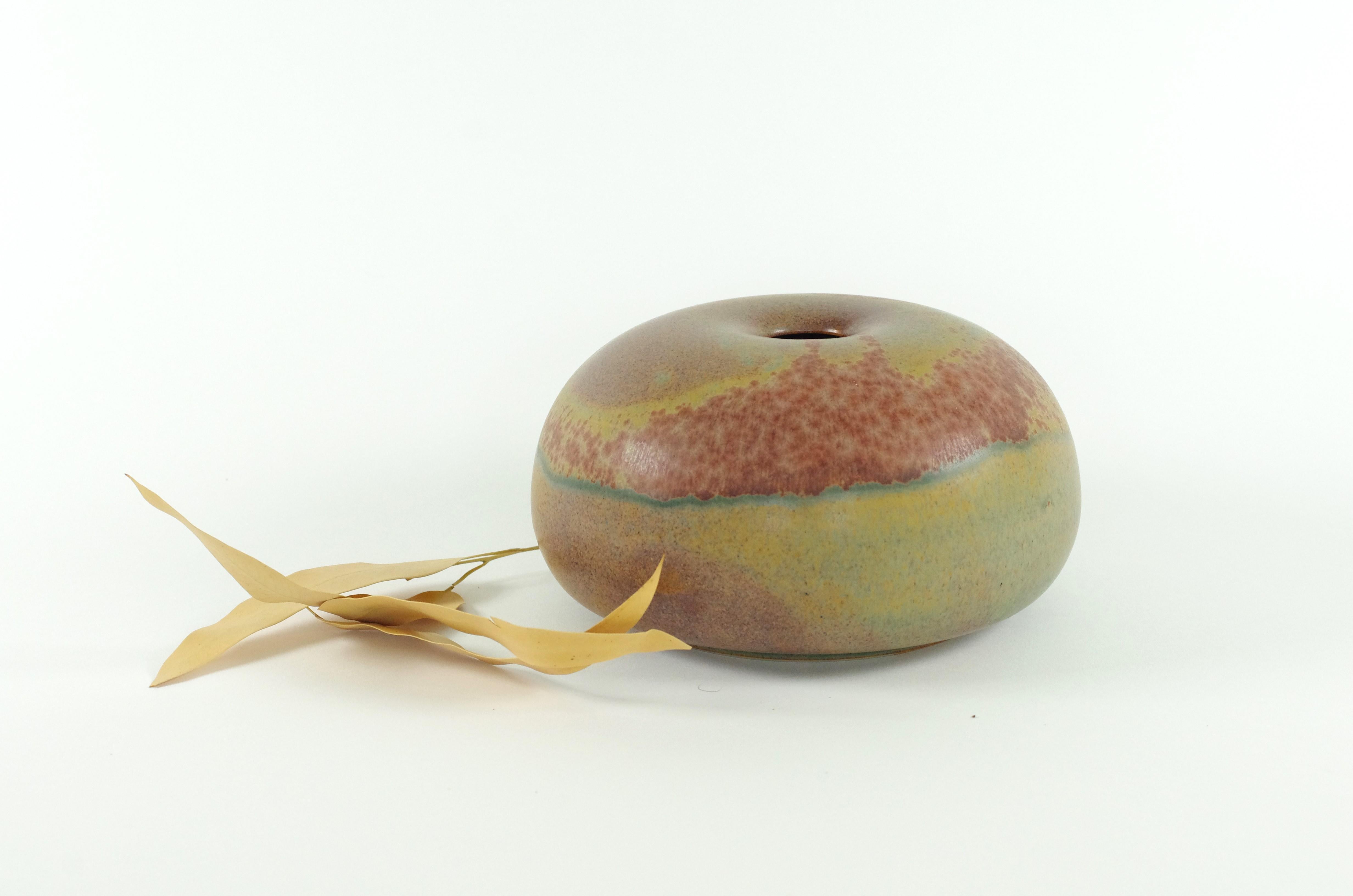 Descrizione del prodotto: 
Questo bellissimo vaso a forma di disco è di origine sconosciuta. Probabilmente è stato prodotto da uno Studio Pottery in Germania. La forma e la patina di questo vaso sono davvero sorprendenti. I colori della patina si