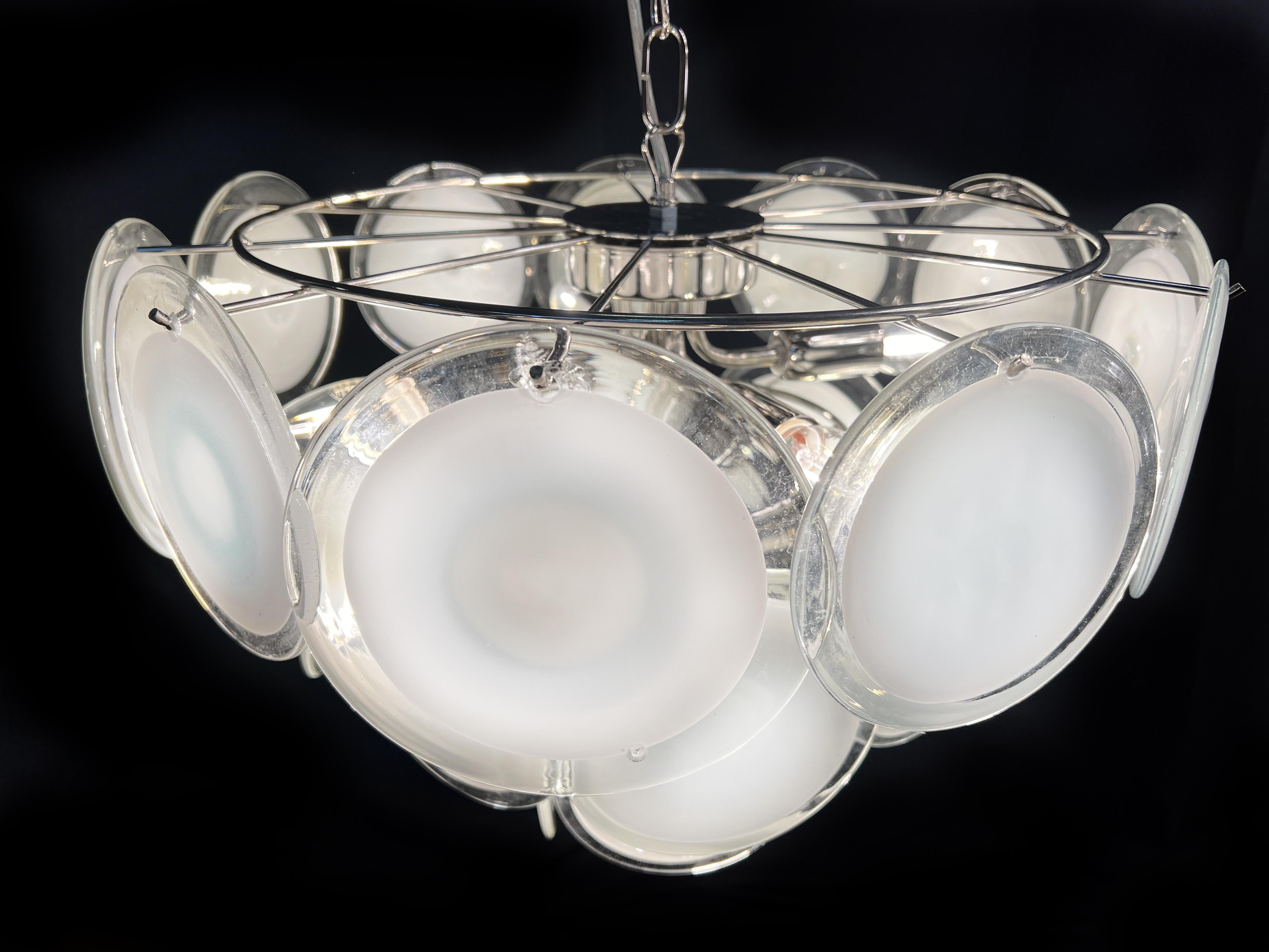 Vintage Italian Murano chandelier by Vistosi. The chandelier has 23 fantastic  white discs in a nickel metal frame.
Period: late XX century
Dimensions: 44,50 inches (150 cm) height with chain; 19,40 inches (50 cm) height without chain; 19,40 inches