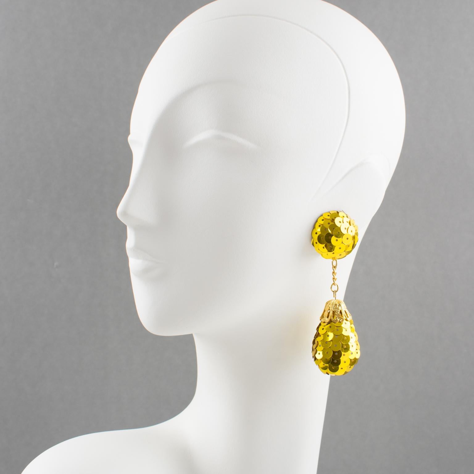 These funky disco chandelier clip-on earrings have a vintage look. They feature a dangling design covered with bright yellow glitter sequins in a large teardrop ball charm shape. There is no visible maker's mark.
The earrings are in good condition,