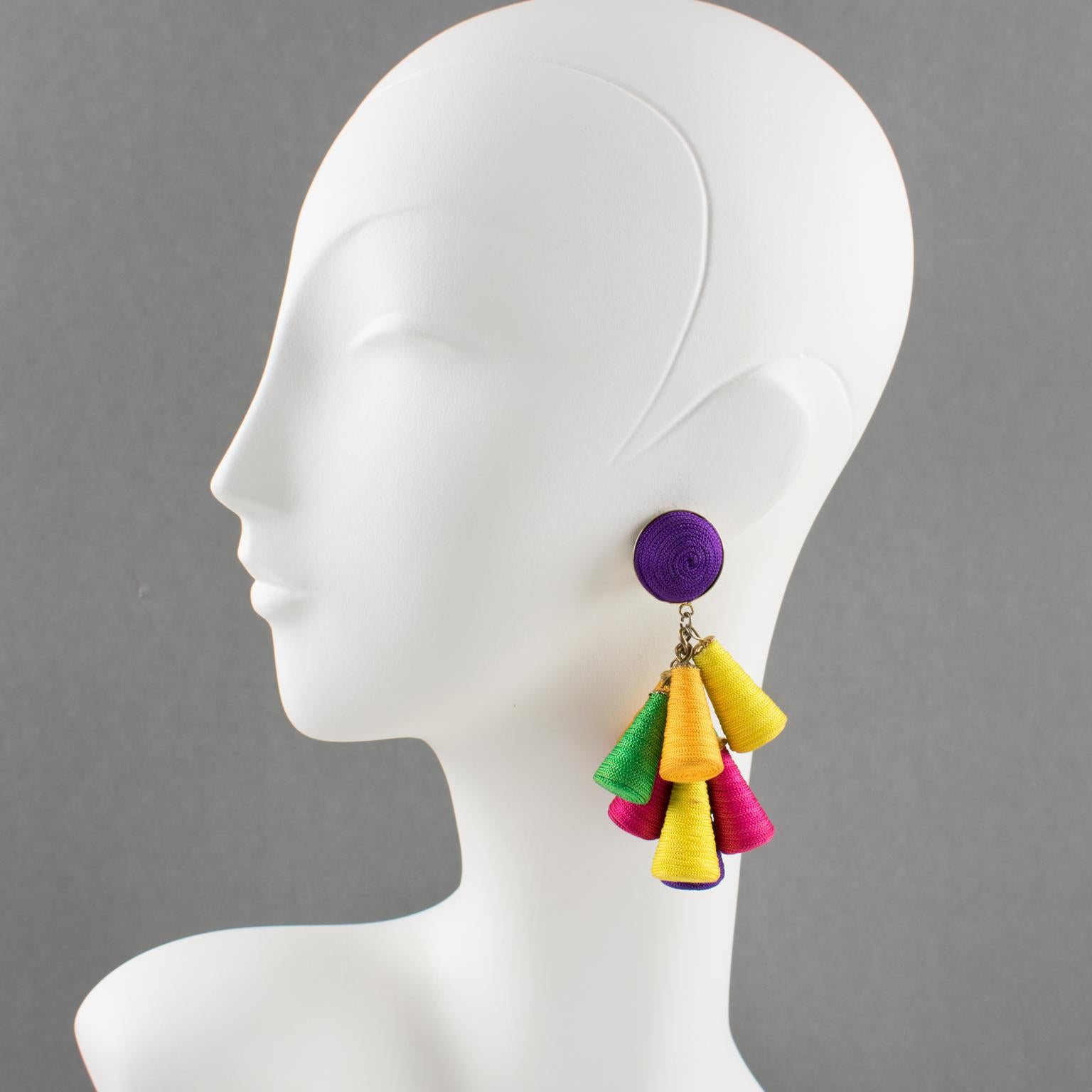 Disco perfection, these clip-on earrings have a vintage look. Oversized long chandelier dangle shape with cone charm elements, all wrapped with multicolor thread. Assorted colors of purple, yellow, green, hot pink, and saffron. There is no visible