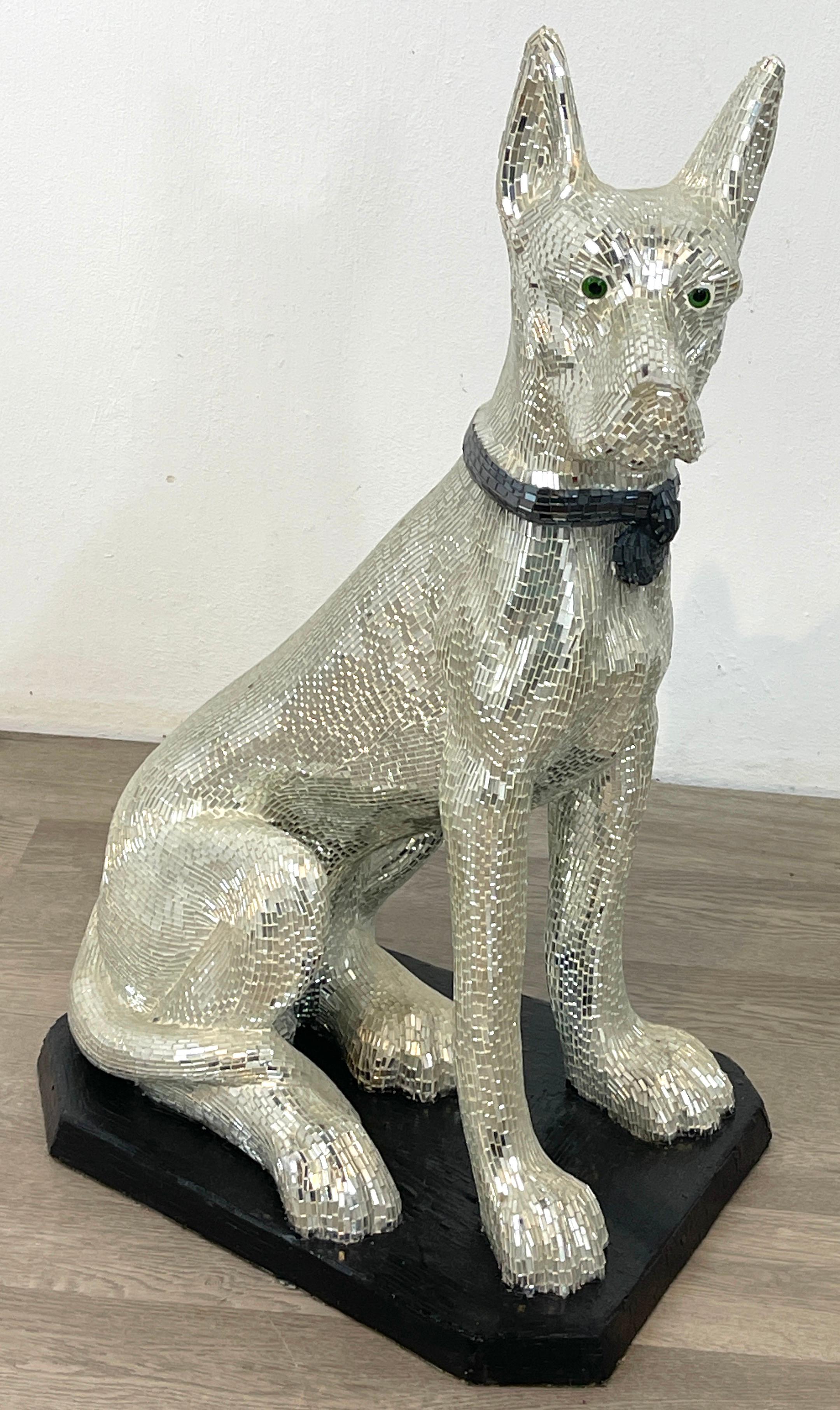 'Disco Dog' mirrored figure of seated great dane with collar
An ambitious work of countless inlaid mosaic mirror covering a seated dog with glass eyes, wearing a 'Sapphire' mirrored collar, resting on ebonized 19
