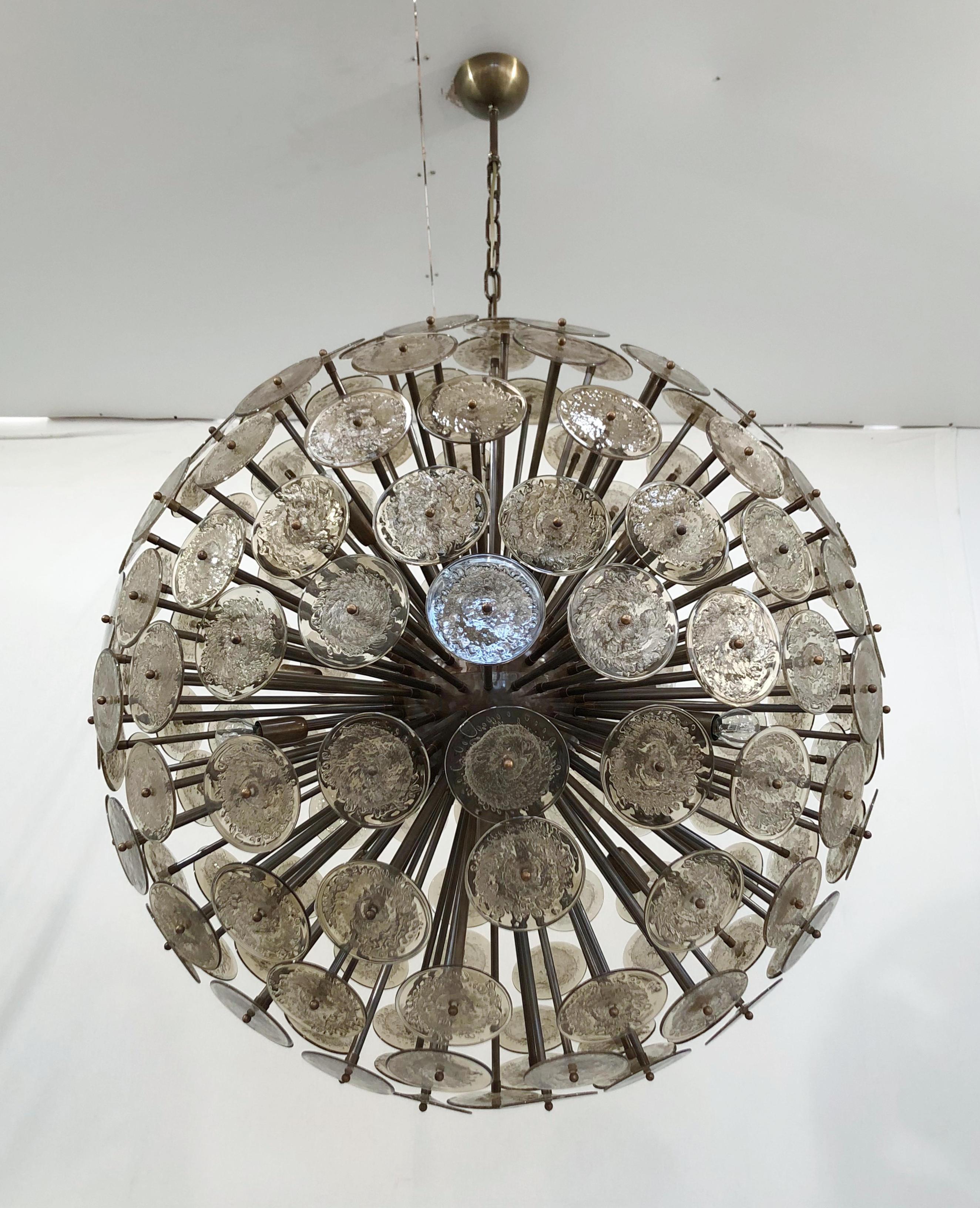 Lampadario italiano a forma di sputnik rotondo con dischi di vetro di Murano marrone fumé soffiati a mano con bolle d'aria secondo la tecnica Pulegoso, montati su una struttura in bronzo scuro, di Fabio Ltd / Made in Italy
16 luci / tipo E26 o E27 /