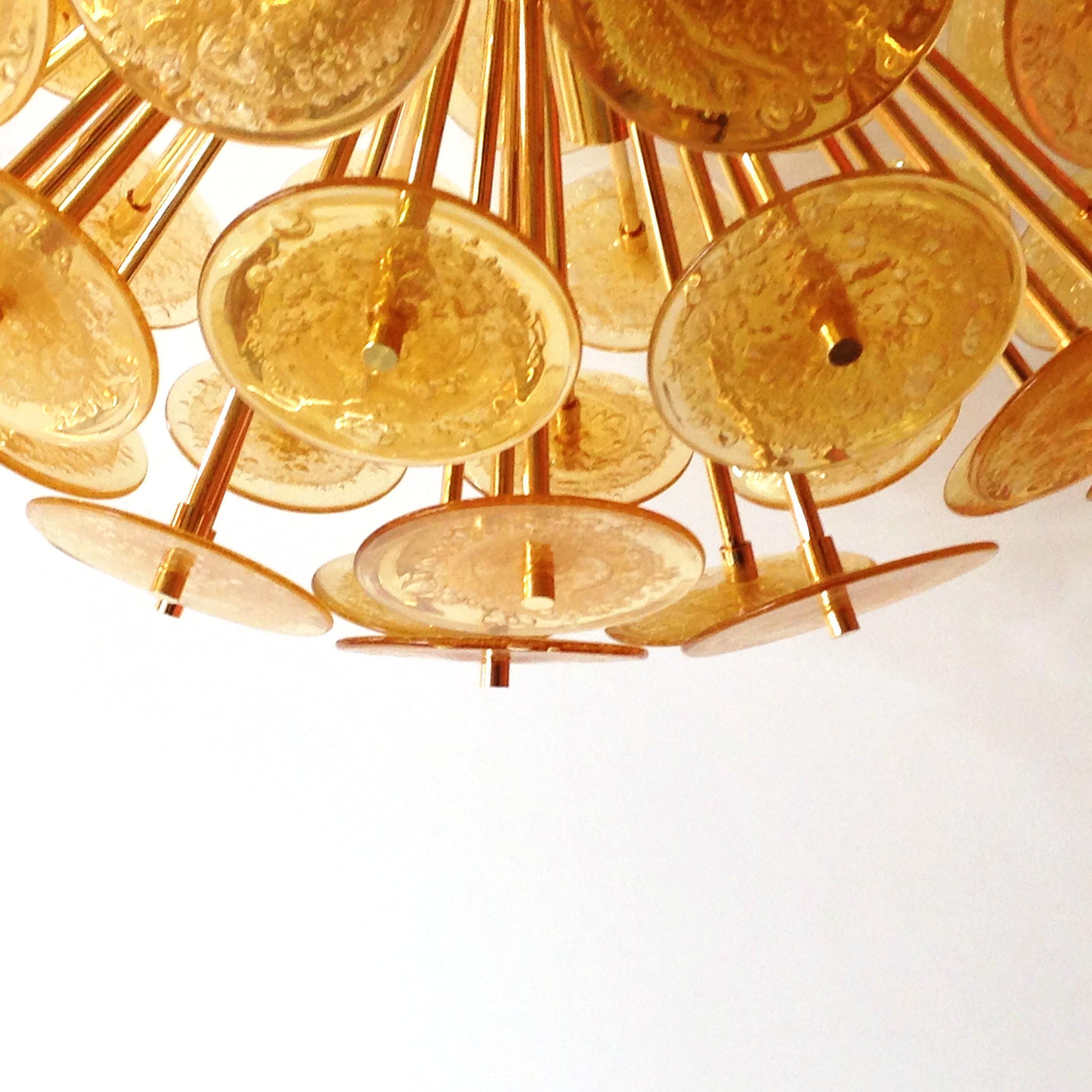 Lampadario italiano a forma di sputnik rotondo con dischi di vetro di Murano ambrato soffiato a bolle con la tecnica Pulegoso, montato su una struttura in metallo placcato oro 24 carati di Fabio Ltd / Made in Italy
12 luci / tipo E26 o E27 / max 60W
