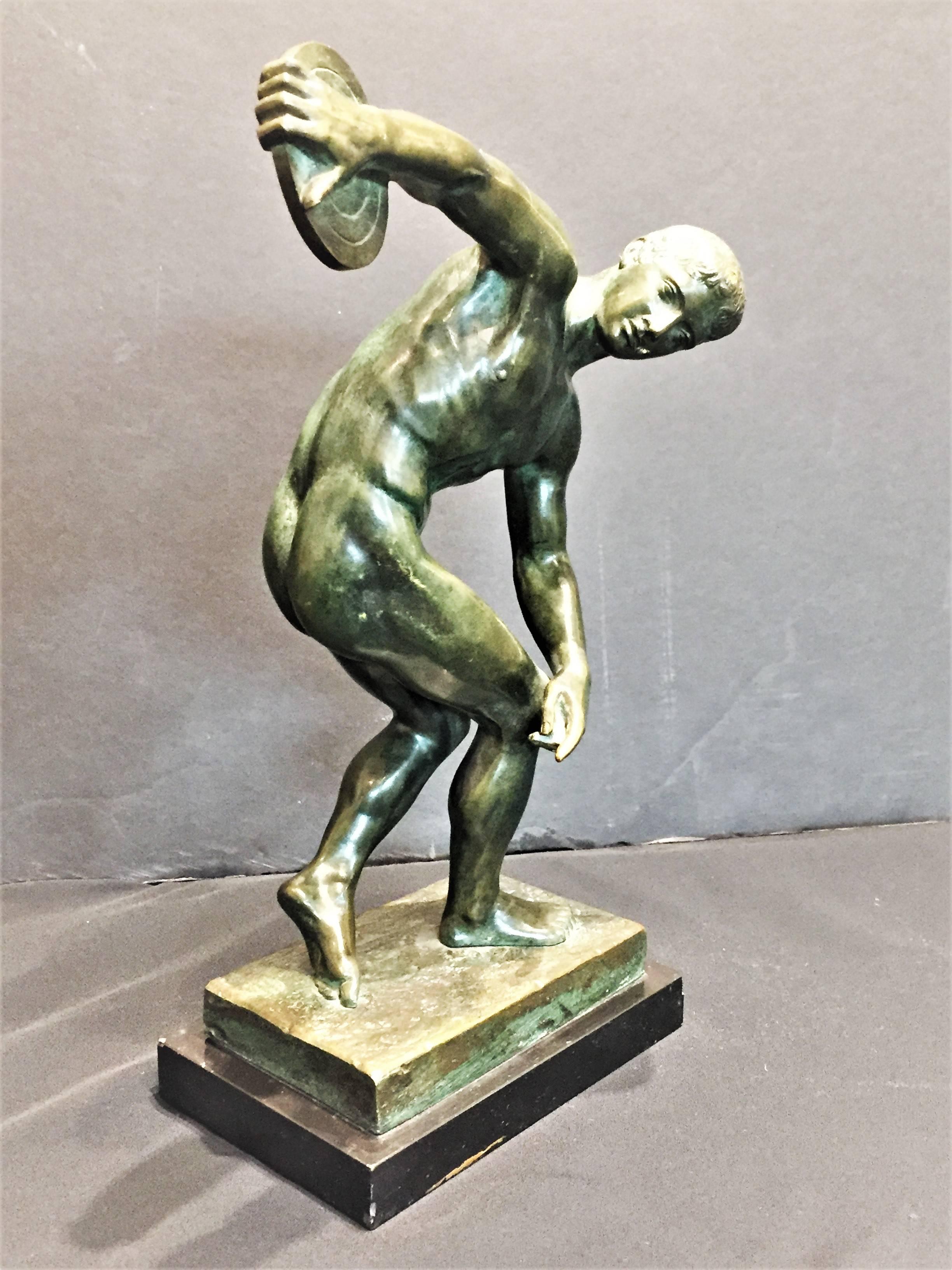 Probably, German. Created in Europe, in the 1920s-1930s, this beautifully founded black and green patinated bronze sculpture on its original wooden base is an Art Deco version of Discobolus (after Discobolus of Myron, a famous Greek sculpture,