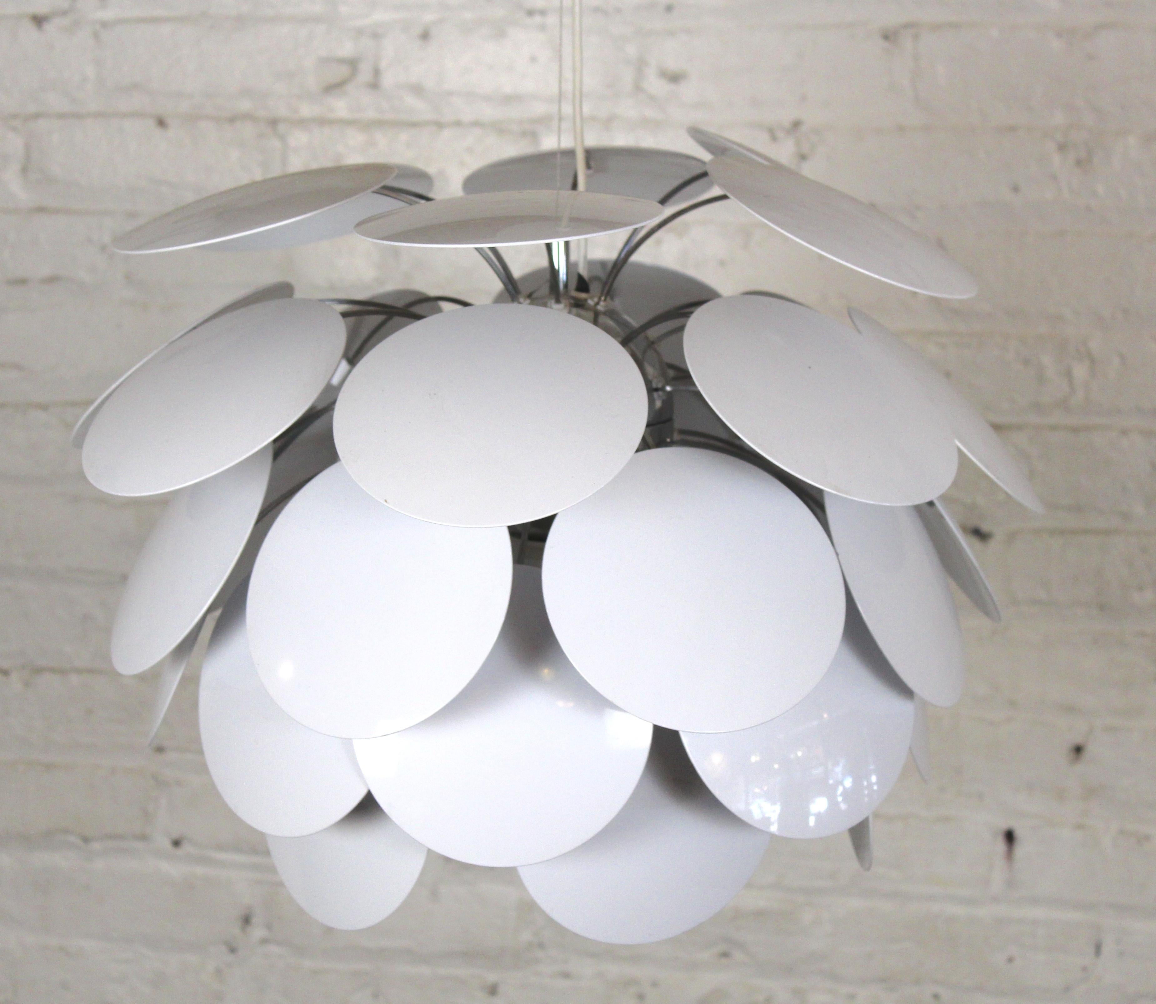 La lámpara colgante diseñada por Christophe Mathieu, de Marset, es una versión moderna de la clásica lámpara de alcachofa de Louis Poulsen. Con discos de plástico redondos que caen en cascada alrededor de un único enchufe para dar una luz cálida y
