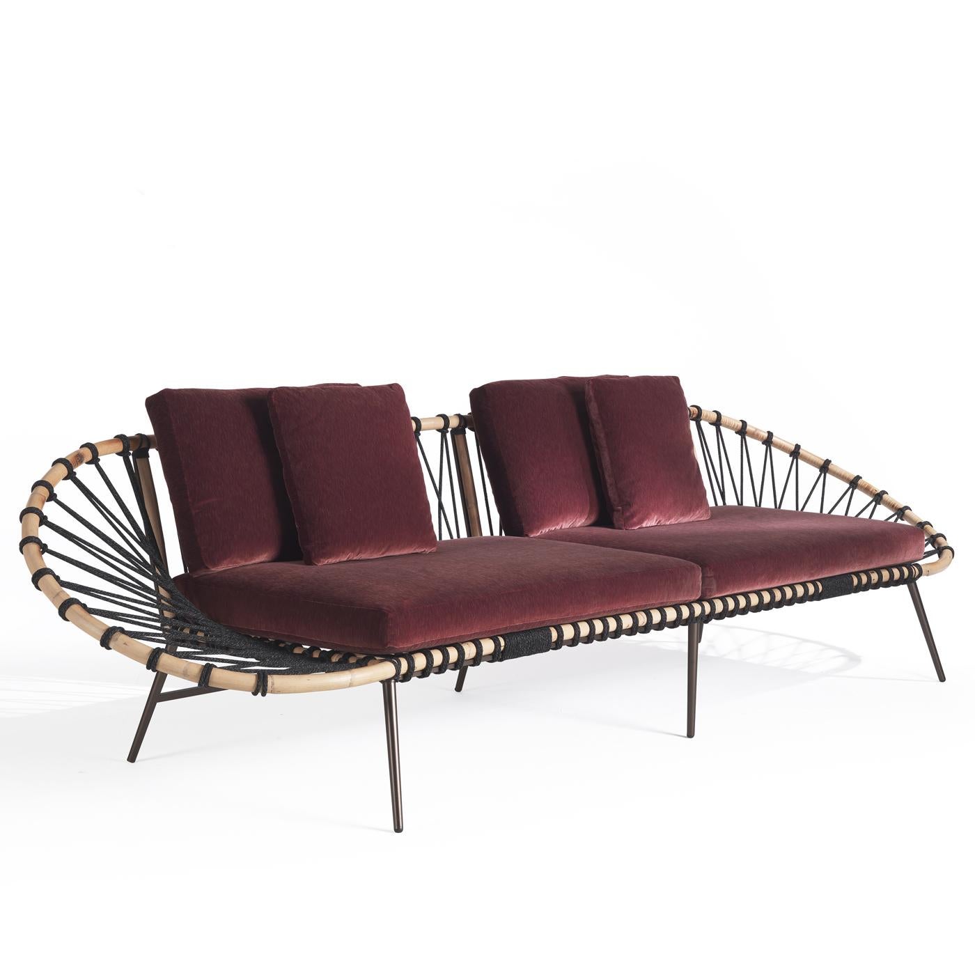 The result of masterful and innovative craftsmanship, this sofa is a strikingly unique piece of design. Resting on metal, slanted feet, its captivating structure is composed of an oval-shaped reed framework covered with braided black rope. The seat