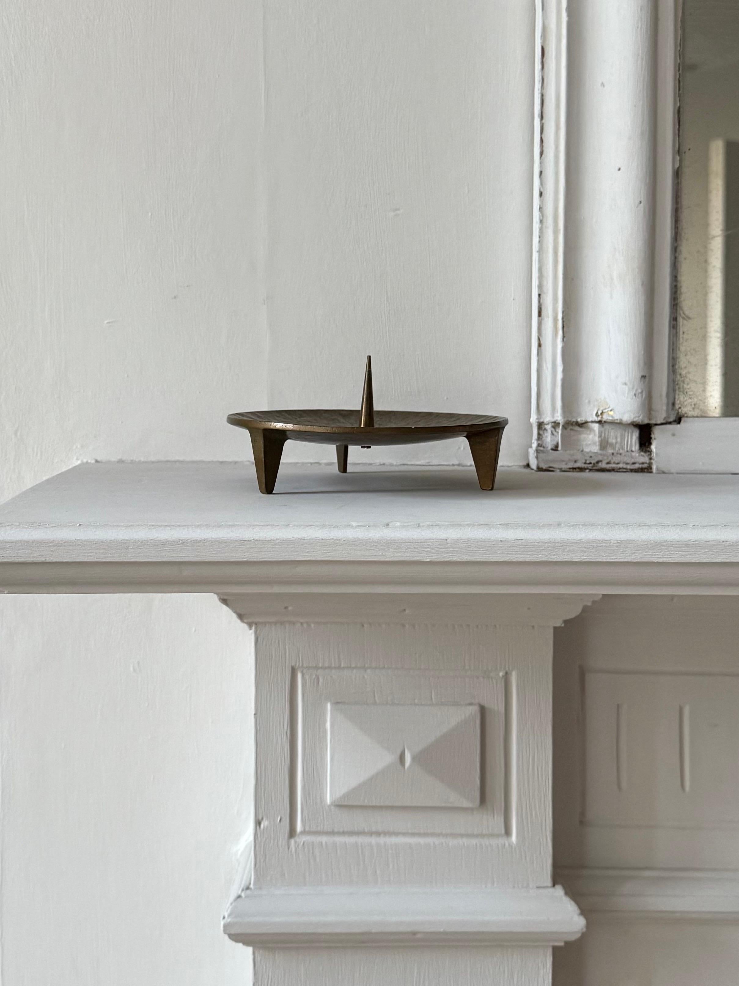 Schlichter, auf drei Füßen stehender Kerzenhalter aus Bronzeguss mit schöner Patina. Zweite Hälfte des zwanzigsten Jahrhunderts, gefunden in Deutschland.

Guter Vintage-Zustand, mit hell- bis mittelbraunen Farbtönen und einigen alters- und