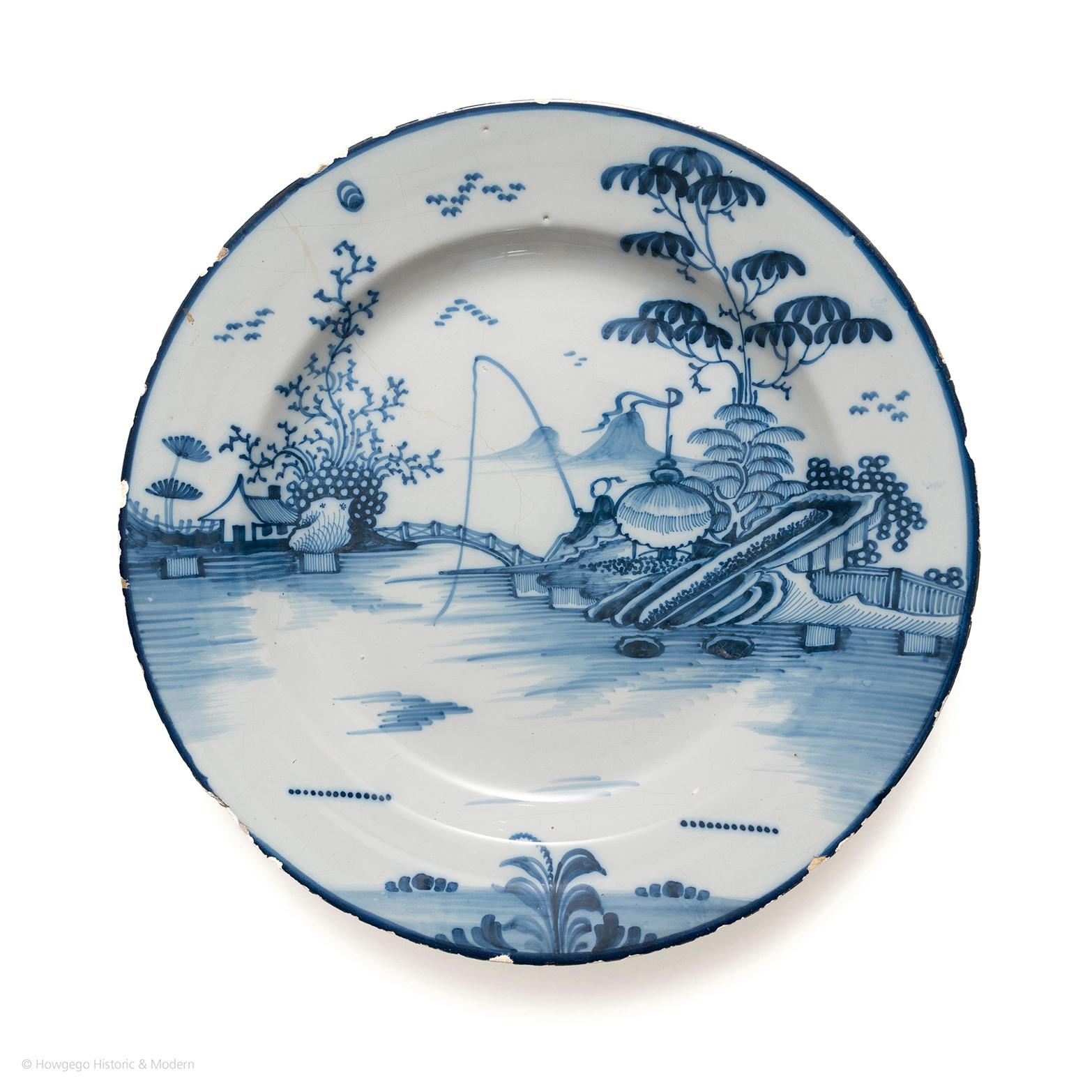 Charming chinoiserie landscape scene depicting the European interpretation of pastoral life in China and the exotic landscape.

Rim-to-rim decoration with a chinoiserie scene of a man fishing on an island by a bridge with mountains on the horizon.