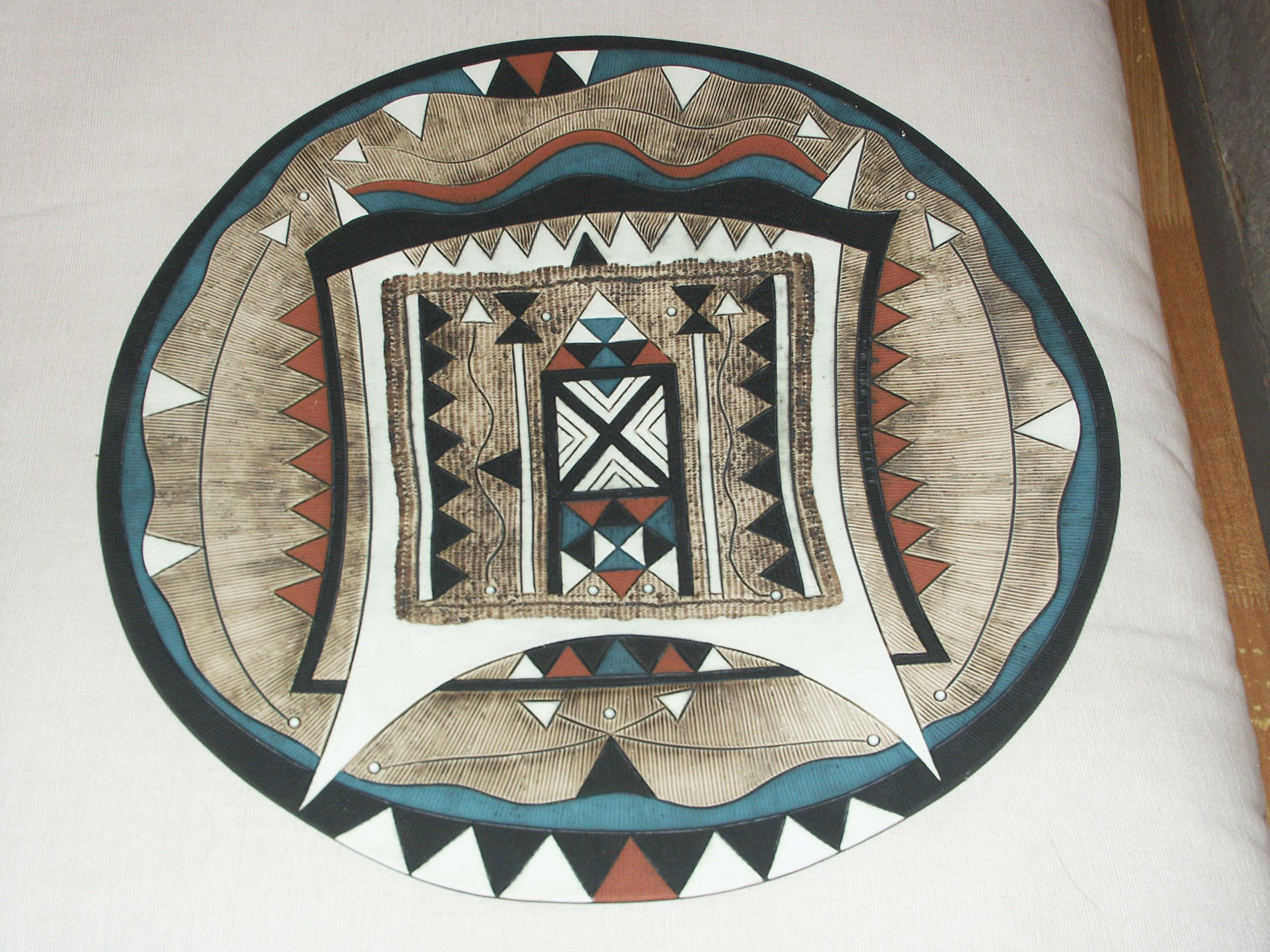 Rodney Alan Blumenfeld South African B.1953.
Round earthenware platter, 1995.
Earthenware clay, press moulded, with metalic oxides and matt glazes.
 
 Rodney Alan Blumenfeld South African B.1953. creates deeply textured, sensual and motif-laden