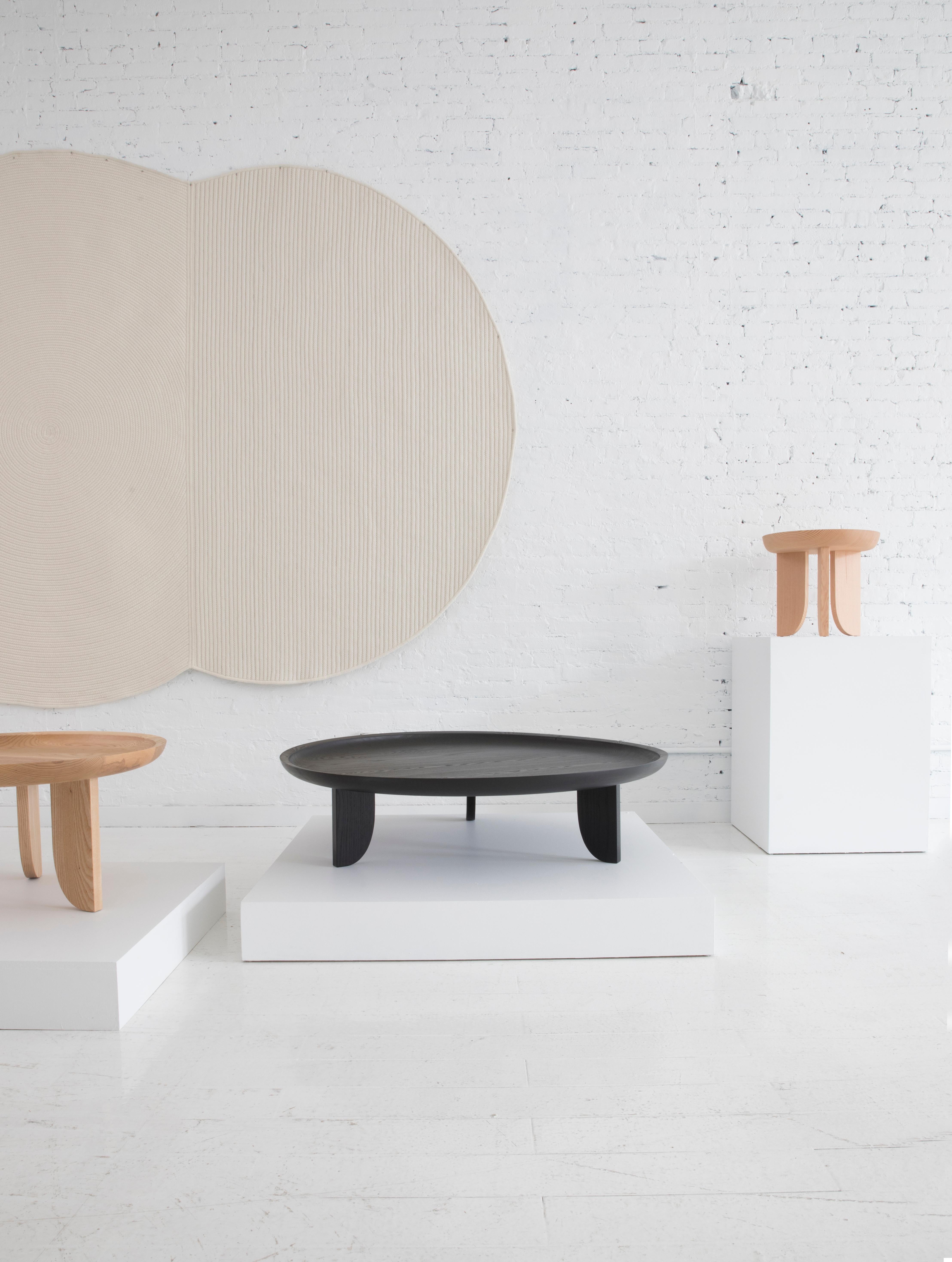 Taking inspiration from hand carved African stools, a scooped out tabletop is created with a little help from technology. A CNC router is used to cut away the wood bowl leaving behind a slope that quickly levels to a flat surface.

Built in the