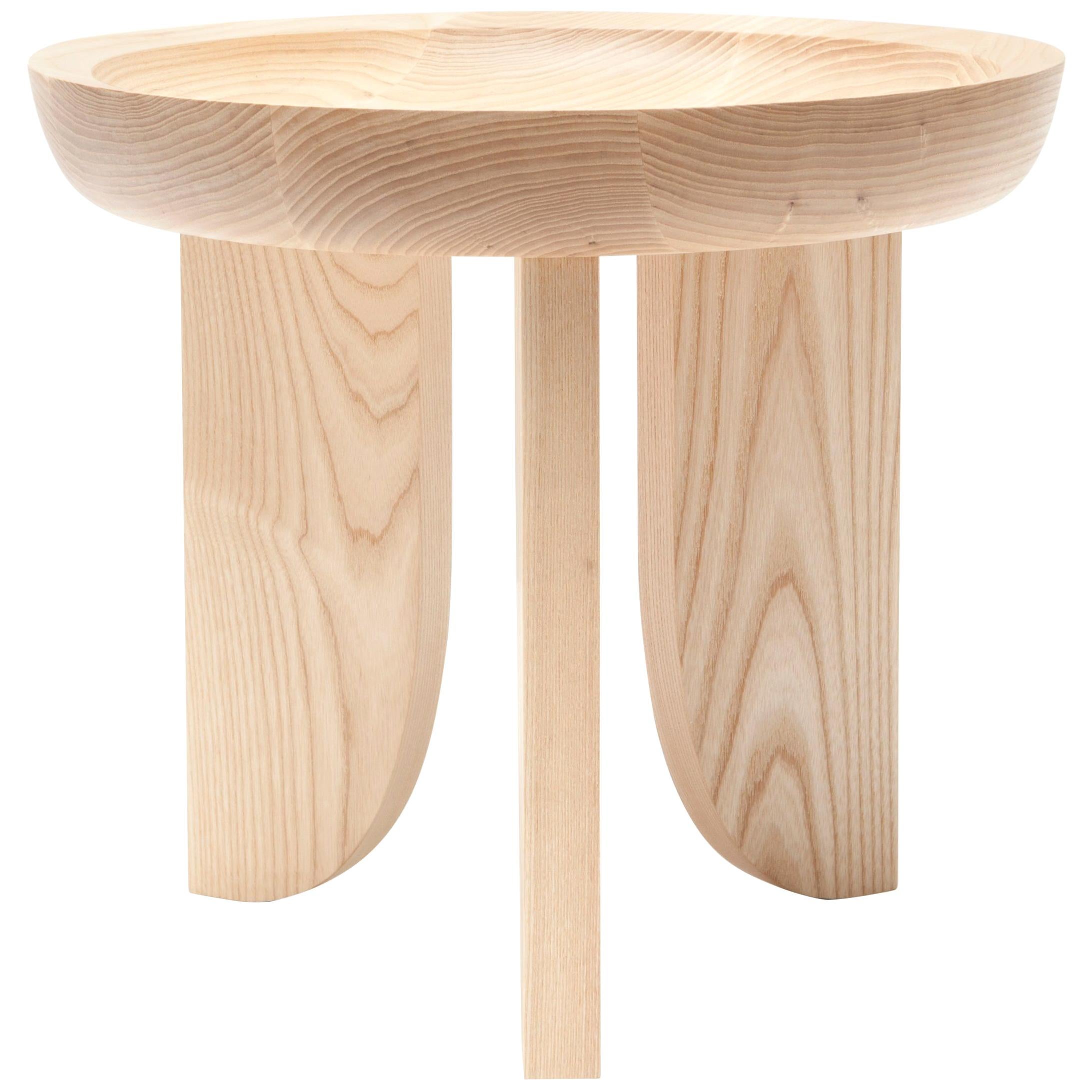 Taking inspiration from hand carved African stools, a scooped out tabletop is created with a little help from technology. A CNC router is used to cut away the wood bowl leaving behind a slope that quickly levels to a flat surface.

Built in the
