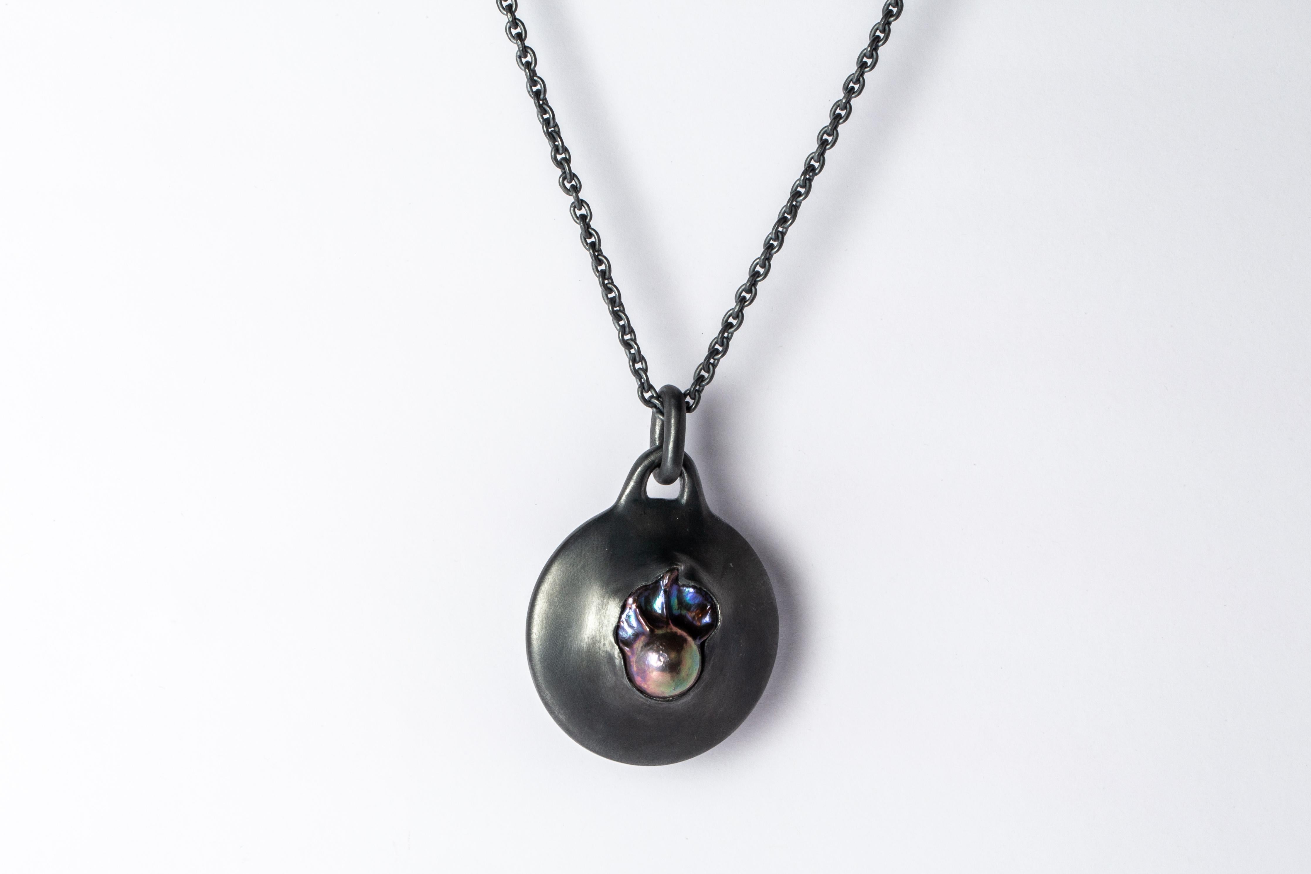 Necklace in the disk shape made in oxidized sterling silver and a bead of black rainbow pearl. This finish may fade over time, which can be considered an enhancement. The Disc family is essentially an Amulet, and they centralize focus onto the