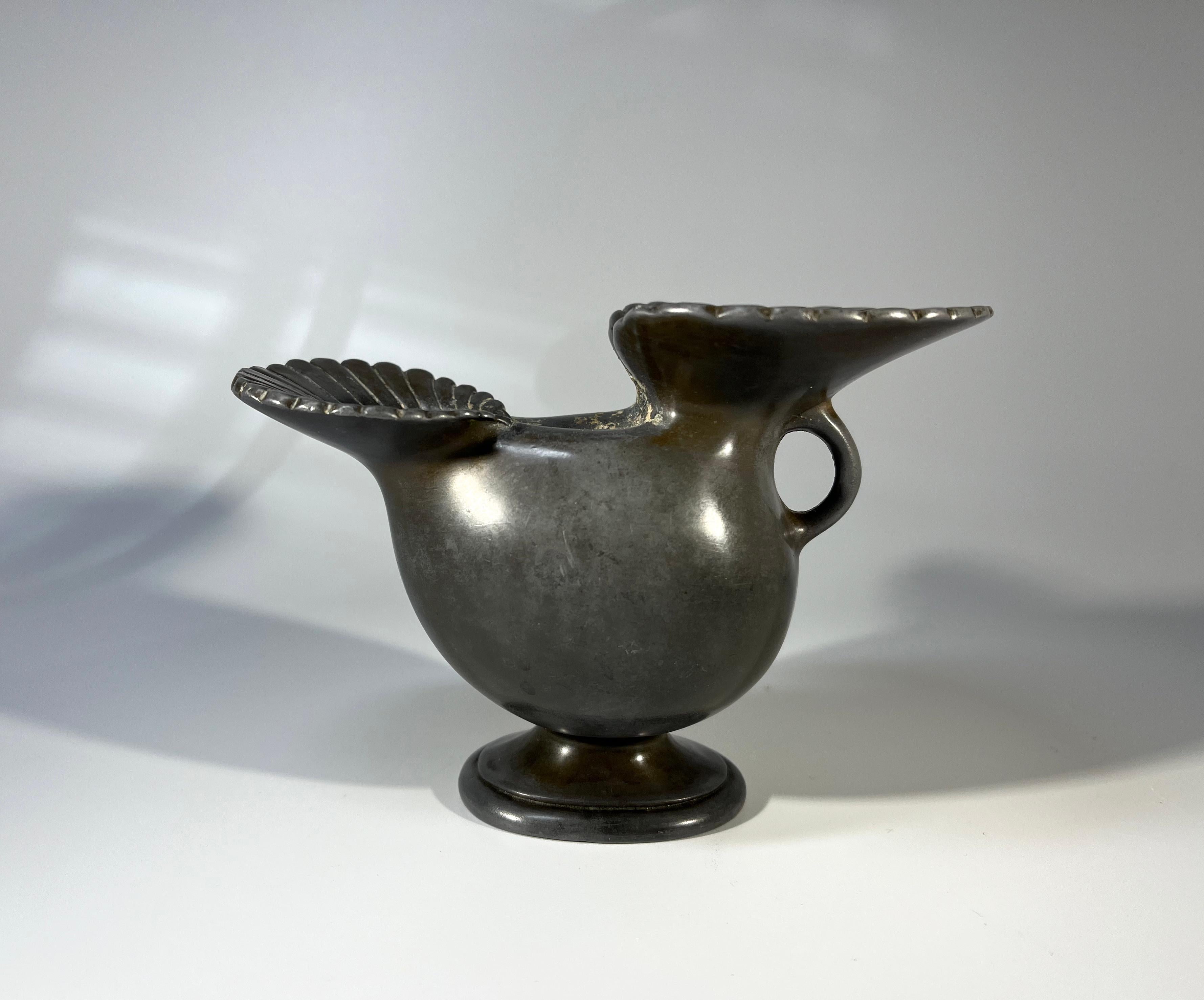 Ce vase bulbeux Just Andersen of Denmark, datant des années 1930, est orné de deux entonnoirs cannelés.
Fabriqué en métal Disko - un métal spécifiquement inventé par Just Andersen en combinant le plomb et l'antimoine.
Estampillé et numéroté D118 à