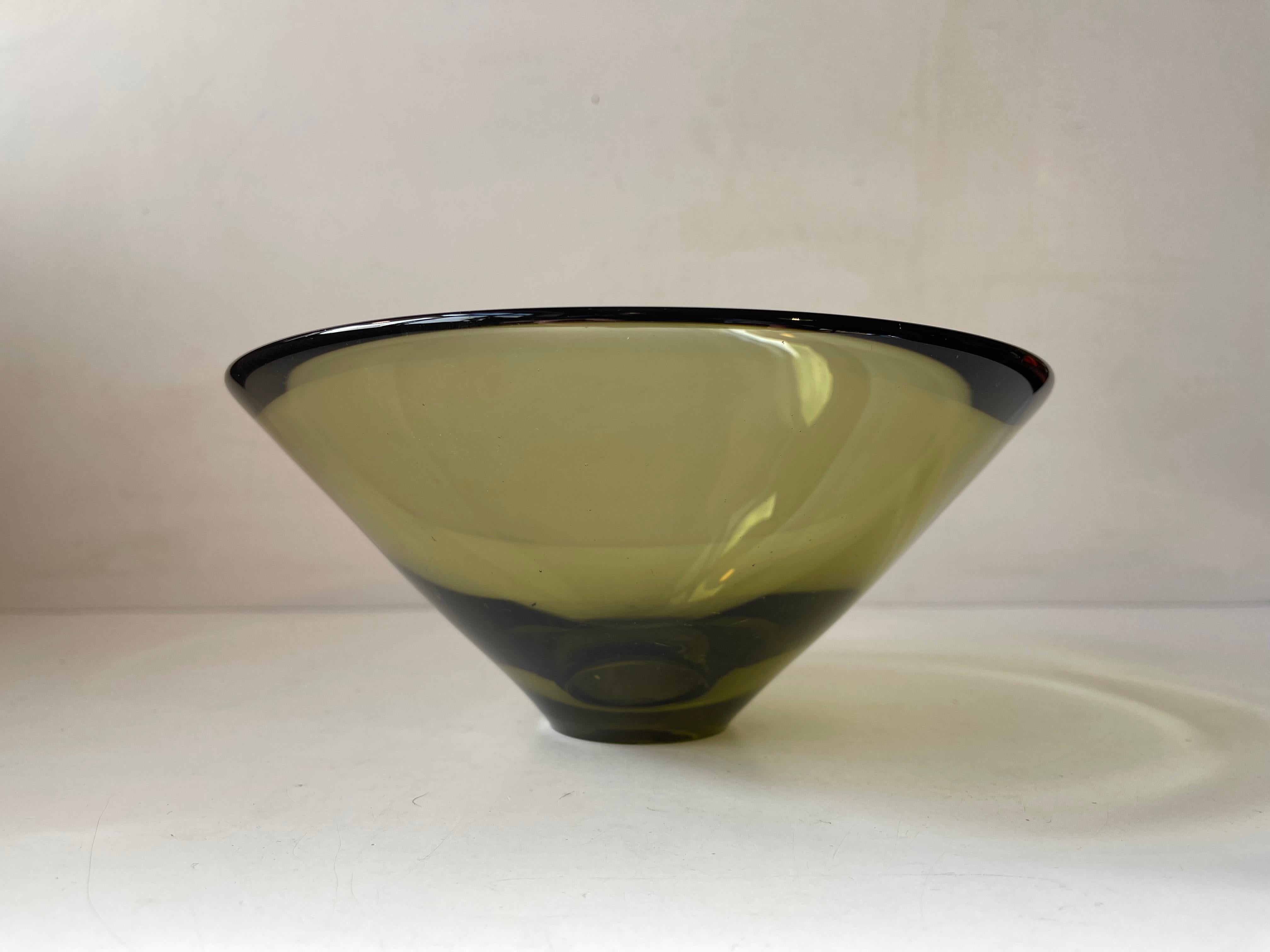 Titled 'Disko' this ultra rare olive green hand-blown glass bowl by Per Lütken was made in 1959. The name Disko has nothing to do with disco. In fact the name was inspired by the reflections of light Lütken experienced visiting Diskobugten/ Disko