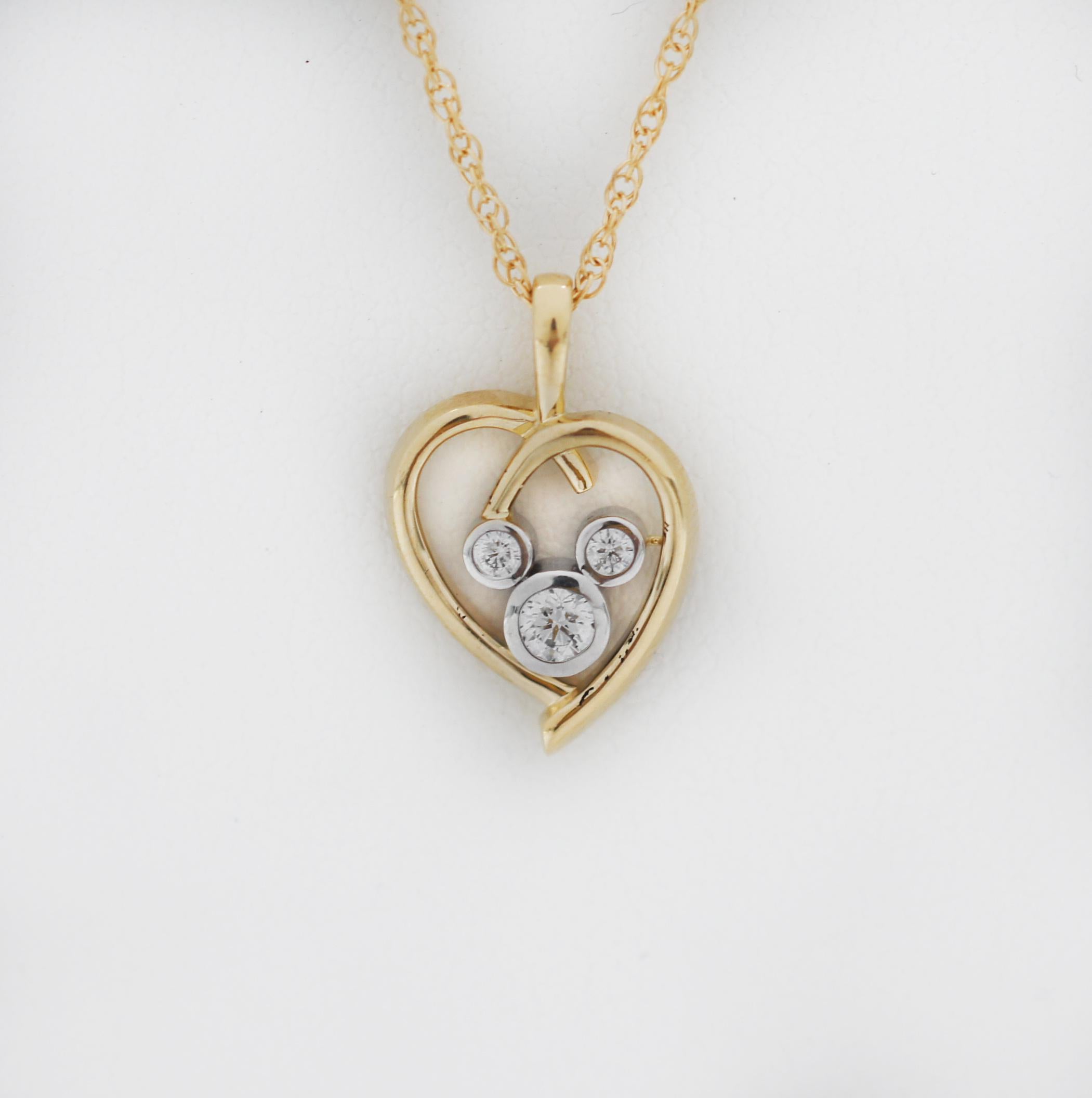 (c) A.I.C.
L'icône de Mickey incrustée de diamants brille dans le cœur en or 14 carats de ce collier Mickey Mouse. Pour les romantiques et les amoureux de Mickey partout, cet élégant collier offrira une vie entière de moments en or.
La magie des
