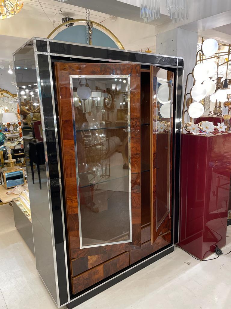 An elegant cabinet finished with black glossy frame decorated with chrome details and burl veneer. Two glass shelves inside and four drawers underneath. 

By Willy Rizzo. 

Excellent vintage condition!