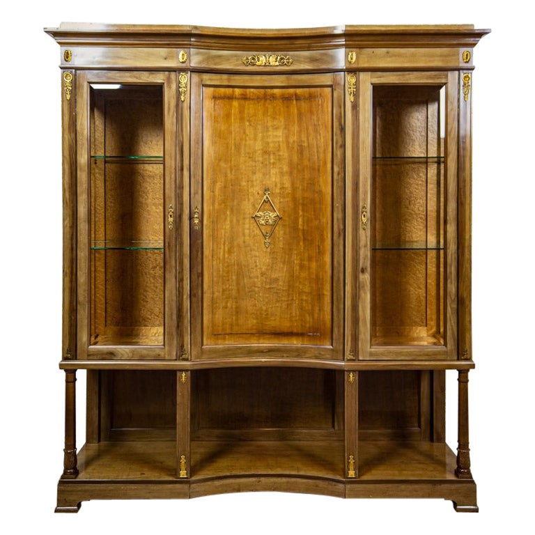 Display Cabinet in the Empire Style with Brass Elements, Early 20th Century

Step into a world of refined elegance with this striking Empire-style display cabinet. Crafted before 1939, its grand three-wing design exudes a timeless charm and